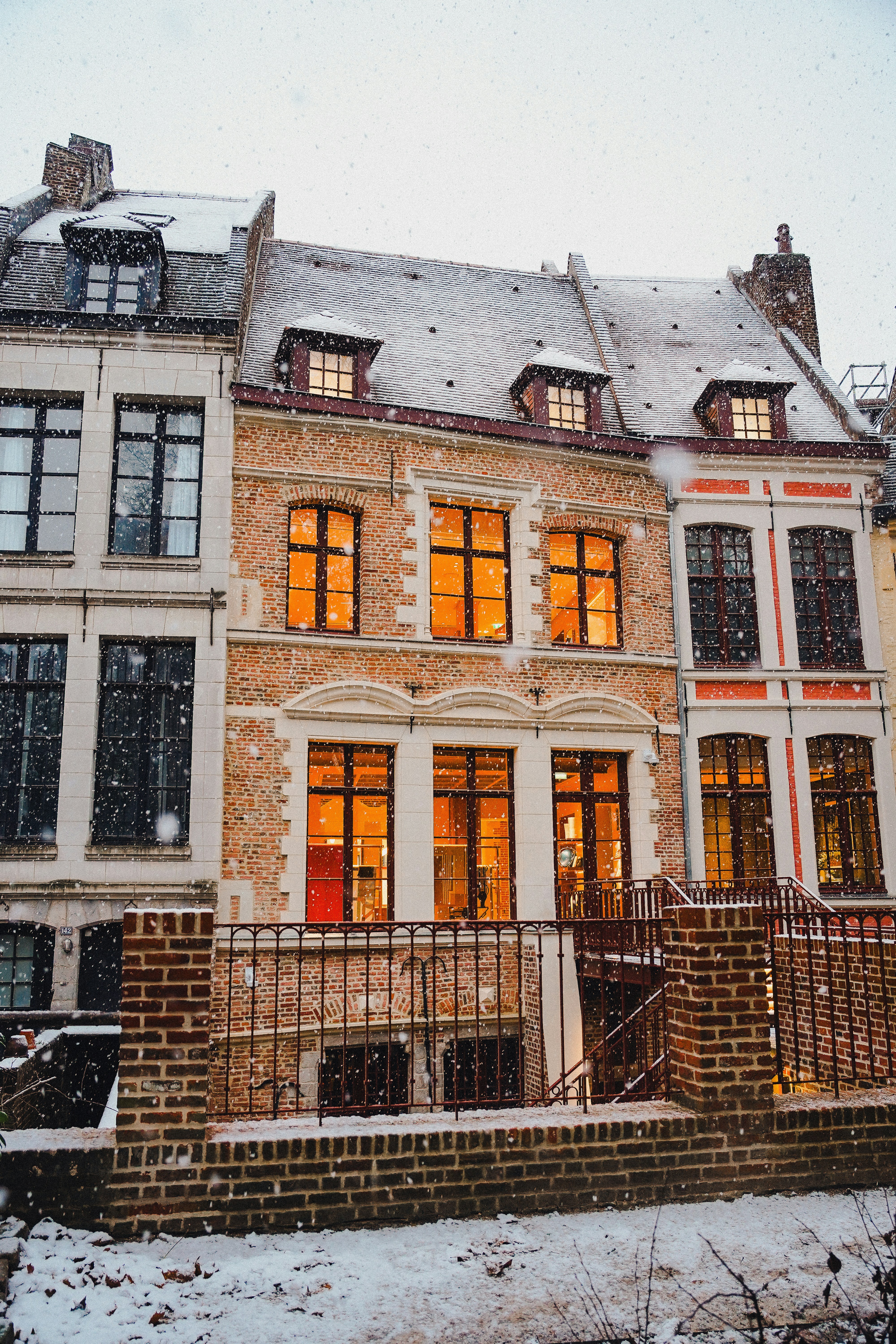 Gemütliche Häuser mit warmen Lichtern während Schneefall