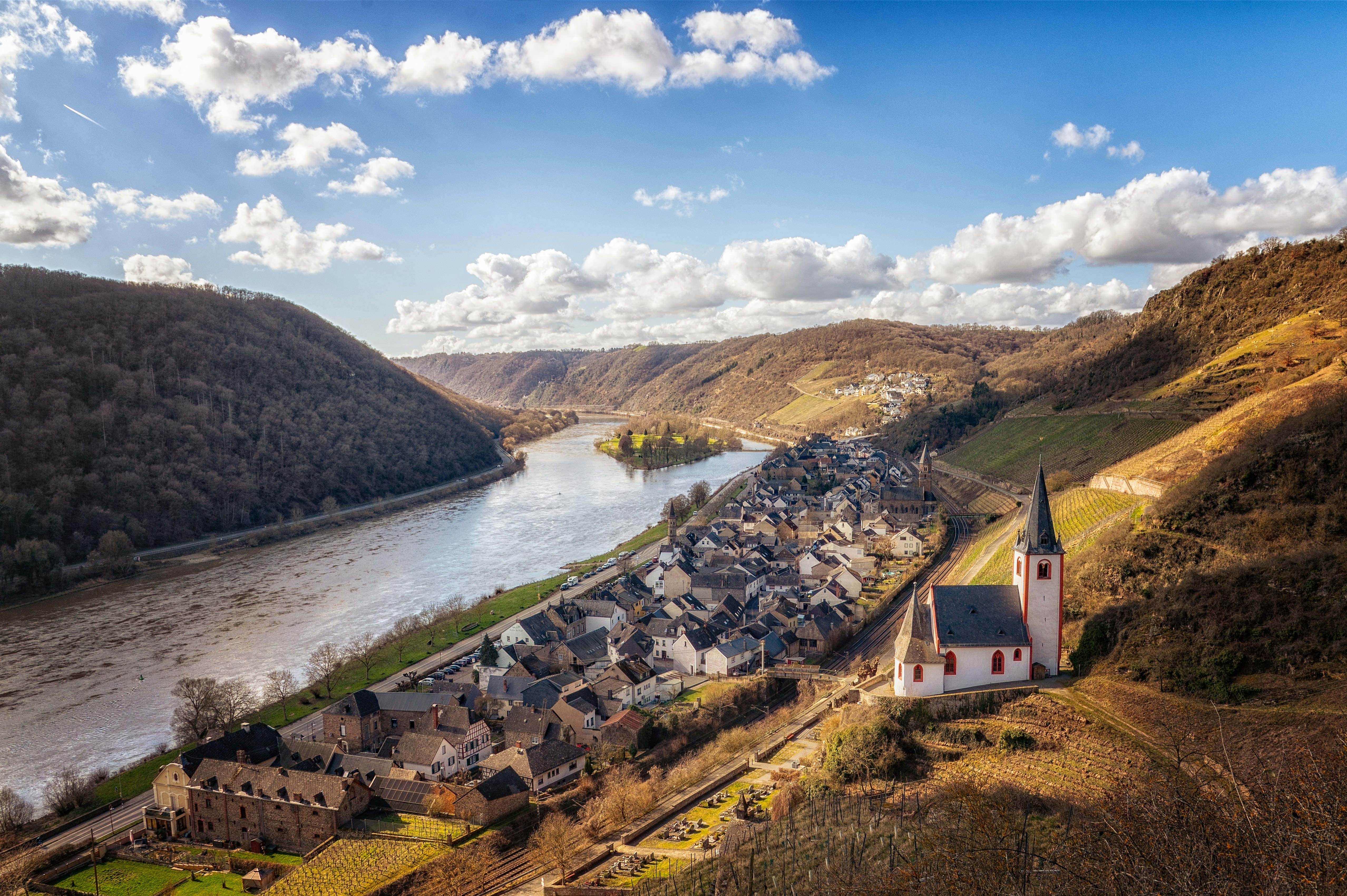 Villaggio incasciato accanto a un fiume tortuoso e a dolci colline.