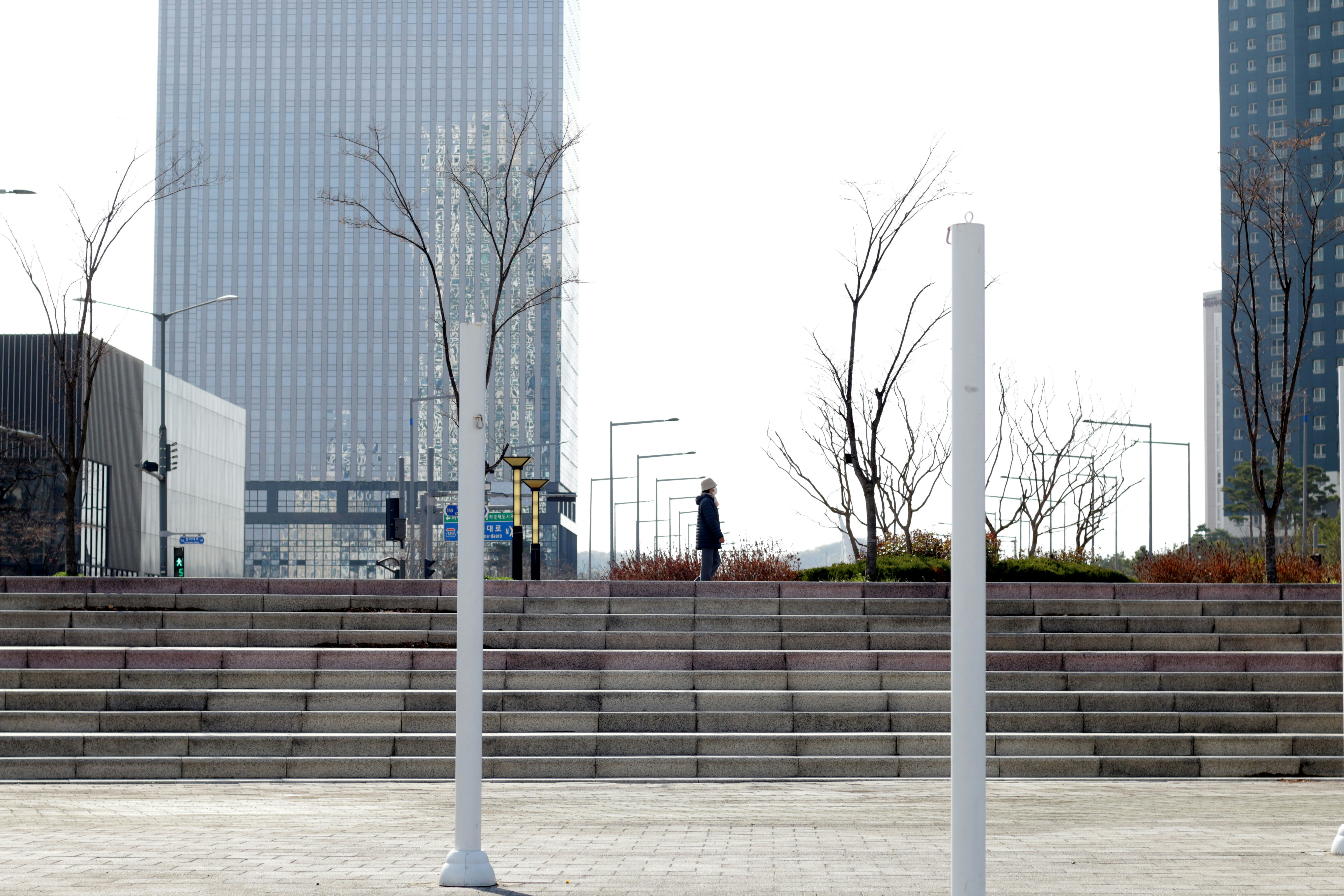 financial transition planning A lone figure walks up stairs in a modern cityscape.