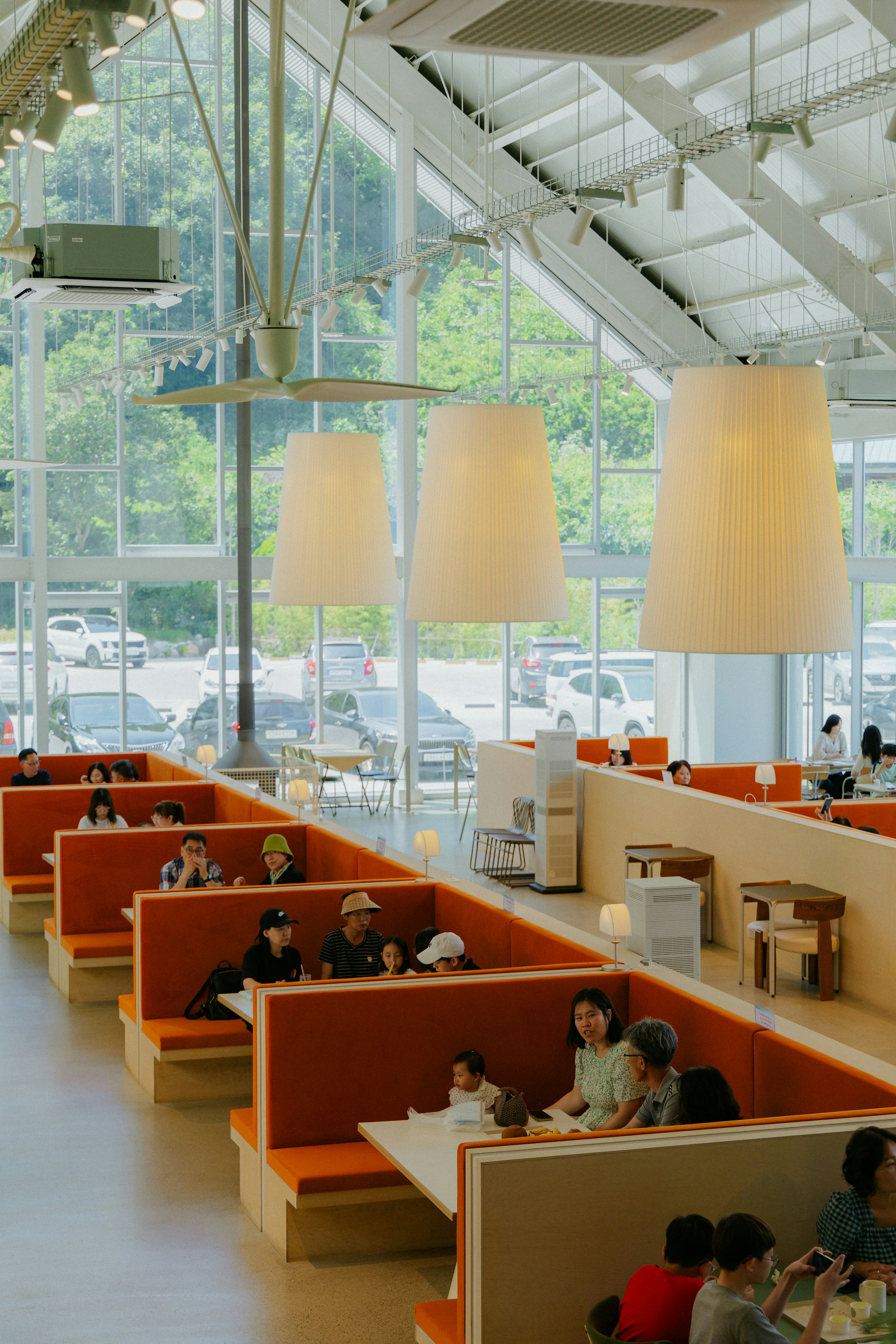 People dining in a bright, modern restaurant with large windows.