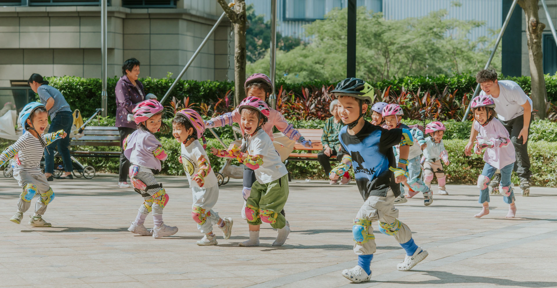 Children wearing helmets play outside on a sunny day.