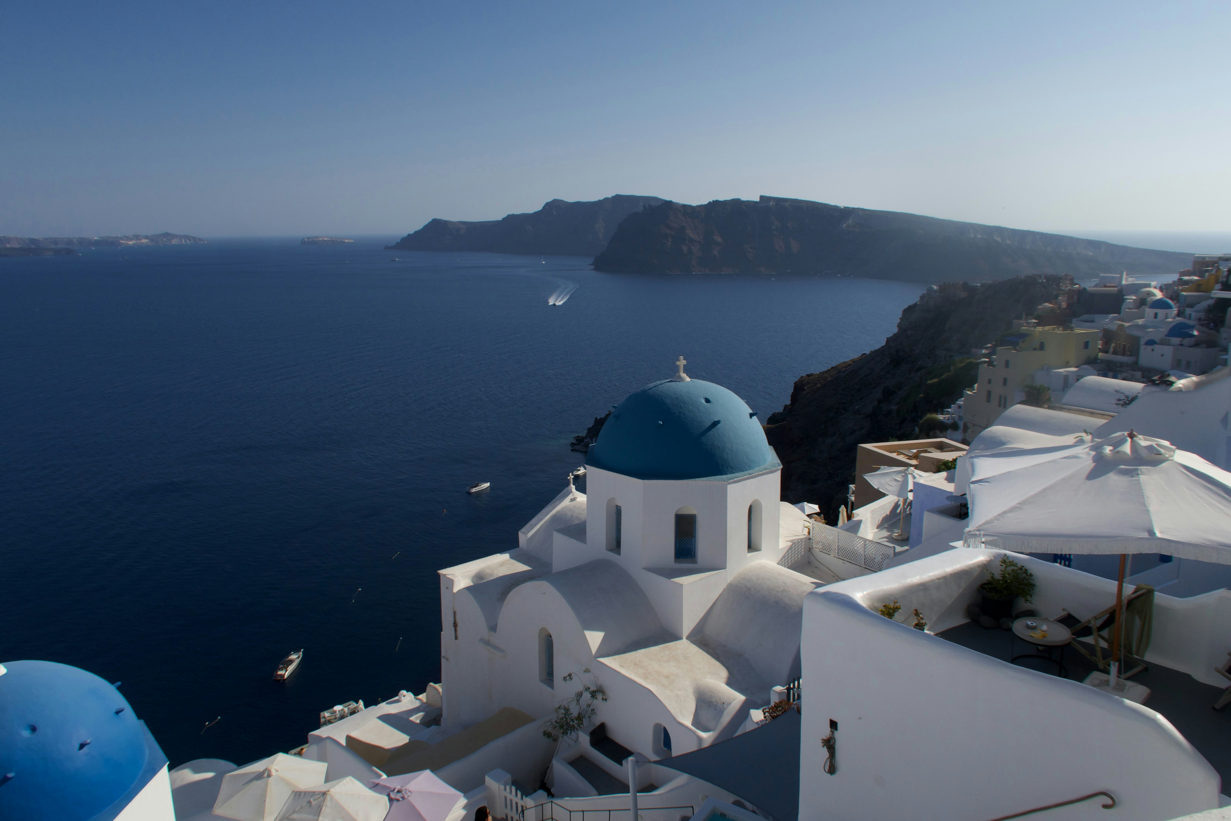 White buildings with blue domes overlooking the sea