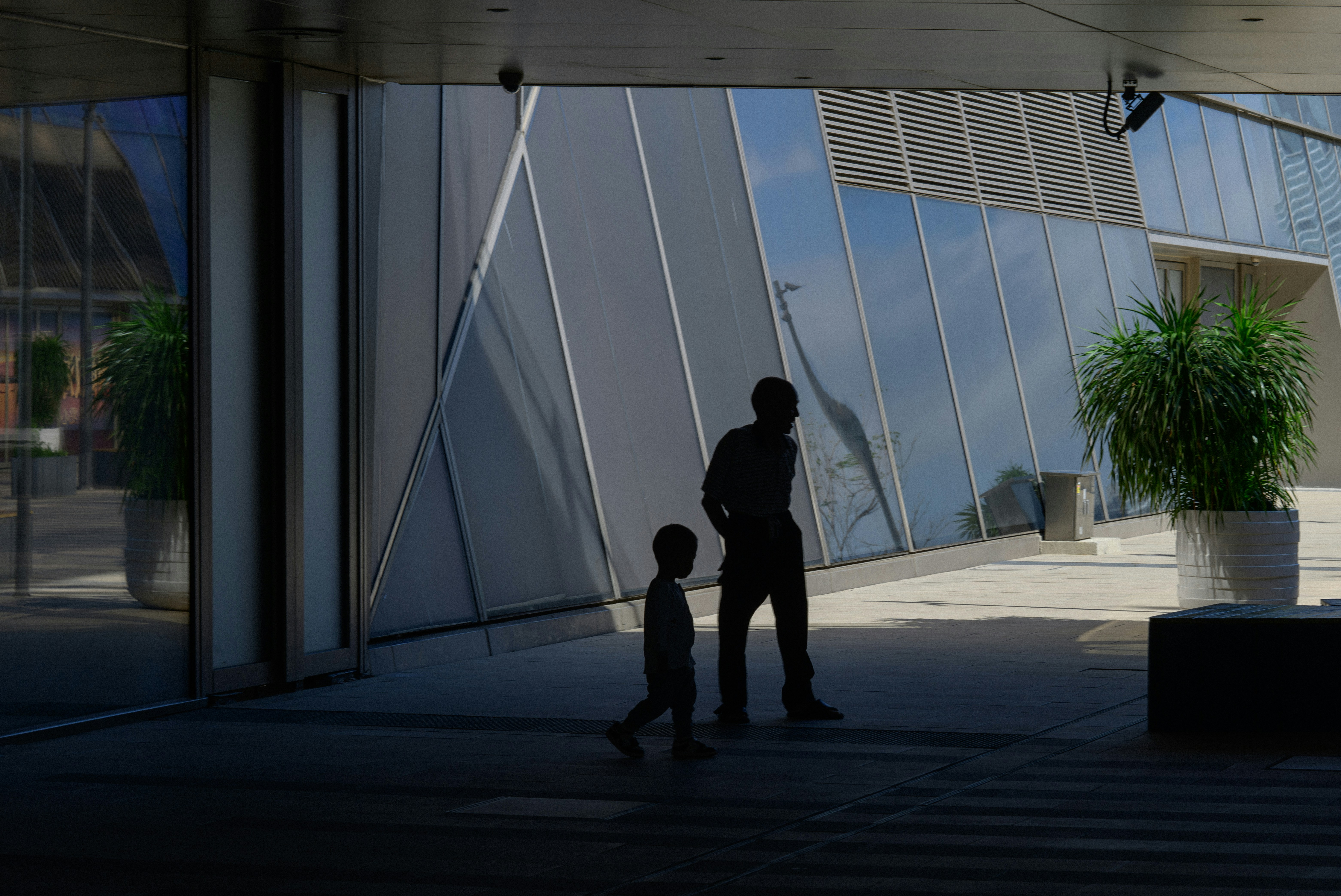 Hombre y niño pasan junto a edificios modernos