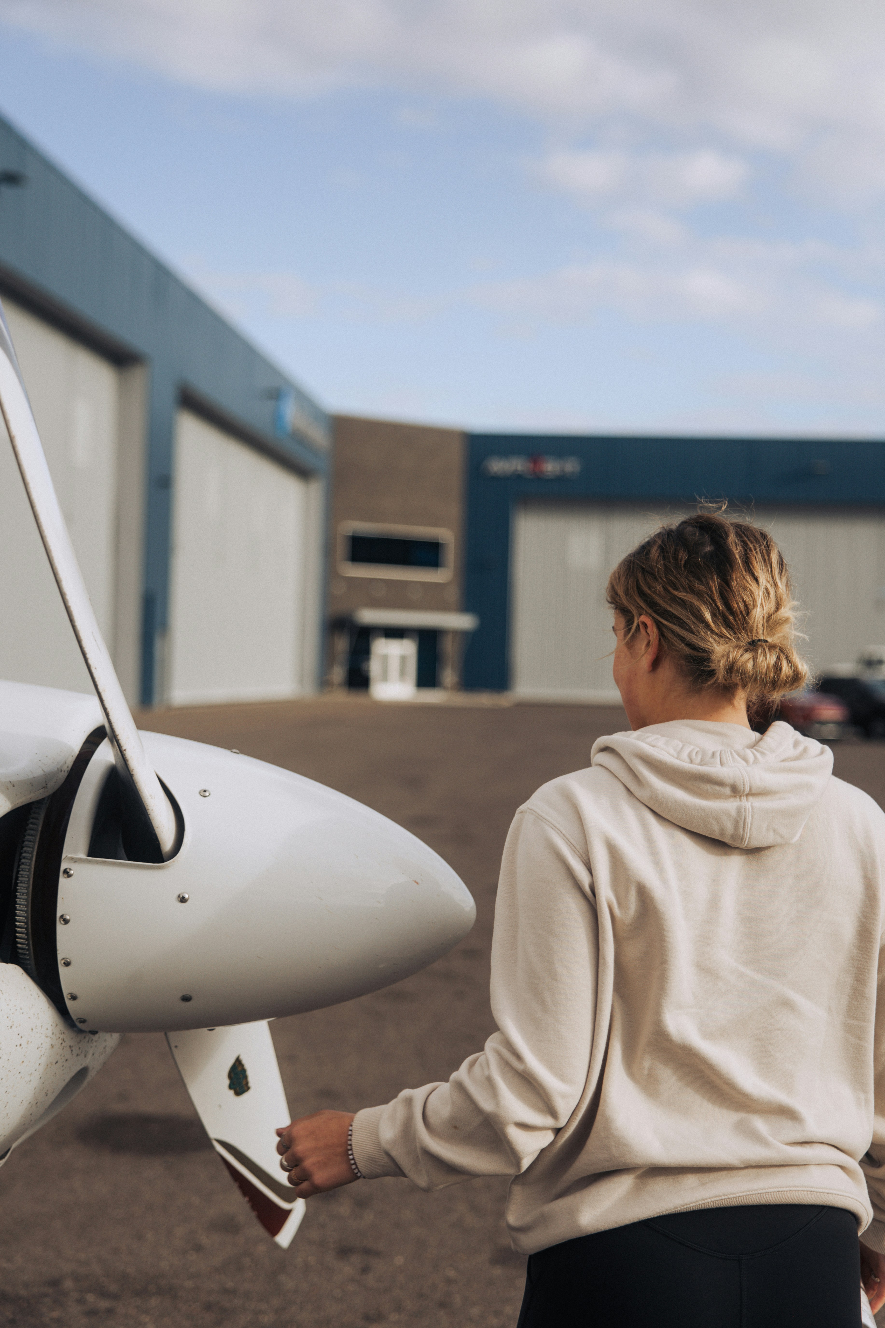 Woman standing by a small airplane propeller