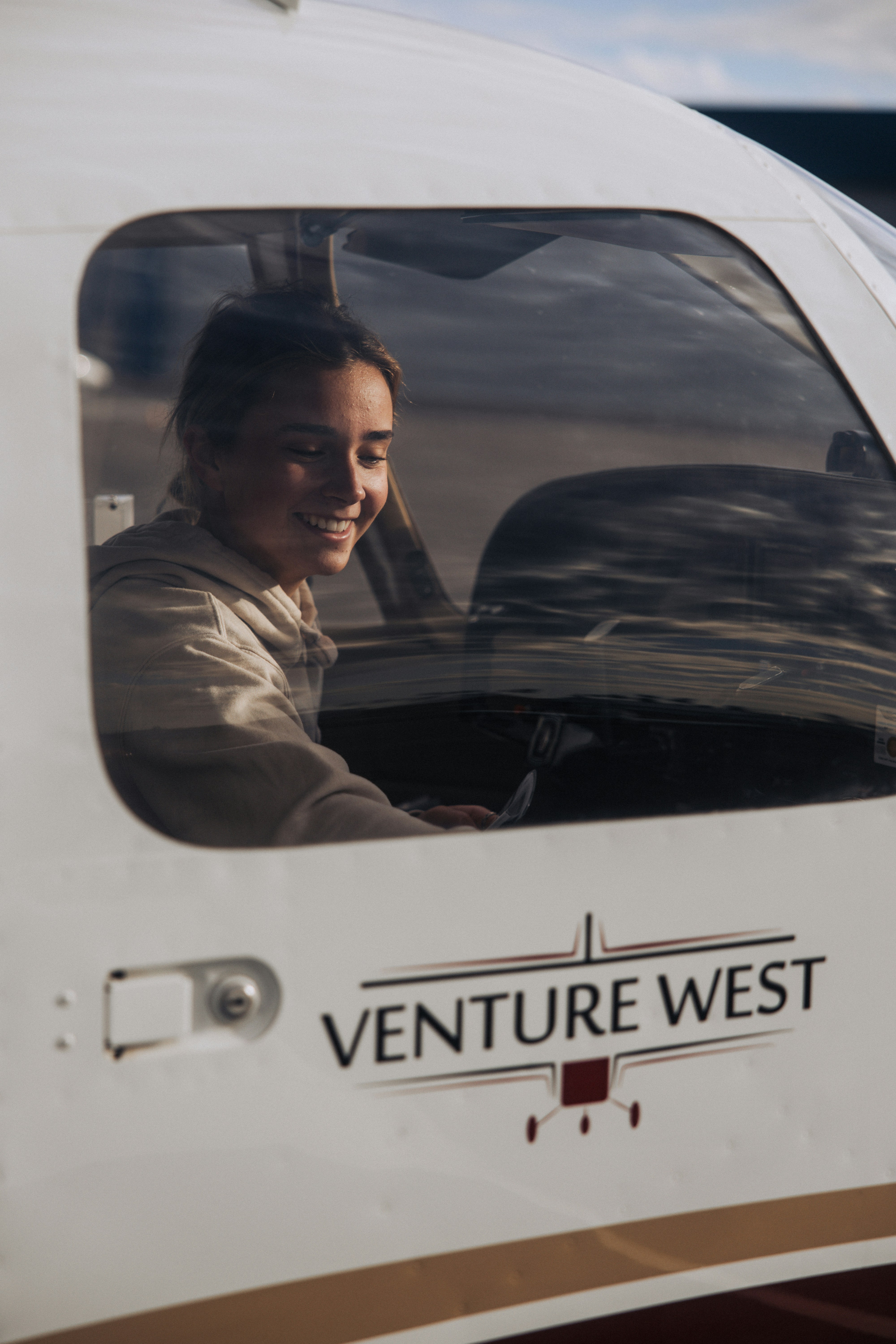 Junge Frau lächelt im Flugzeugcockpit