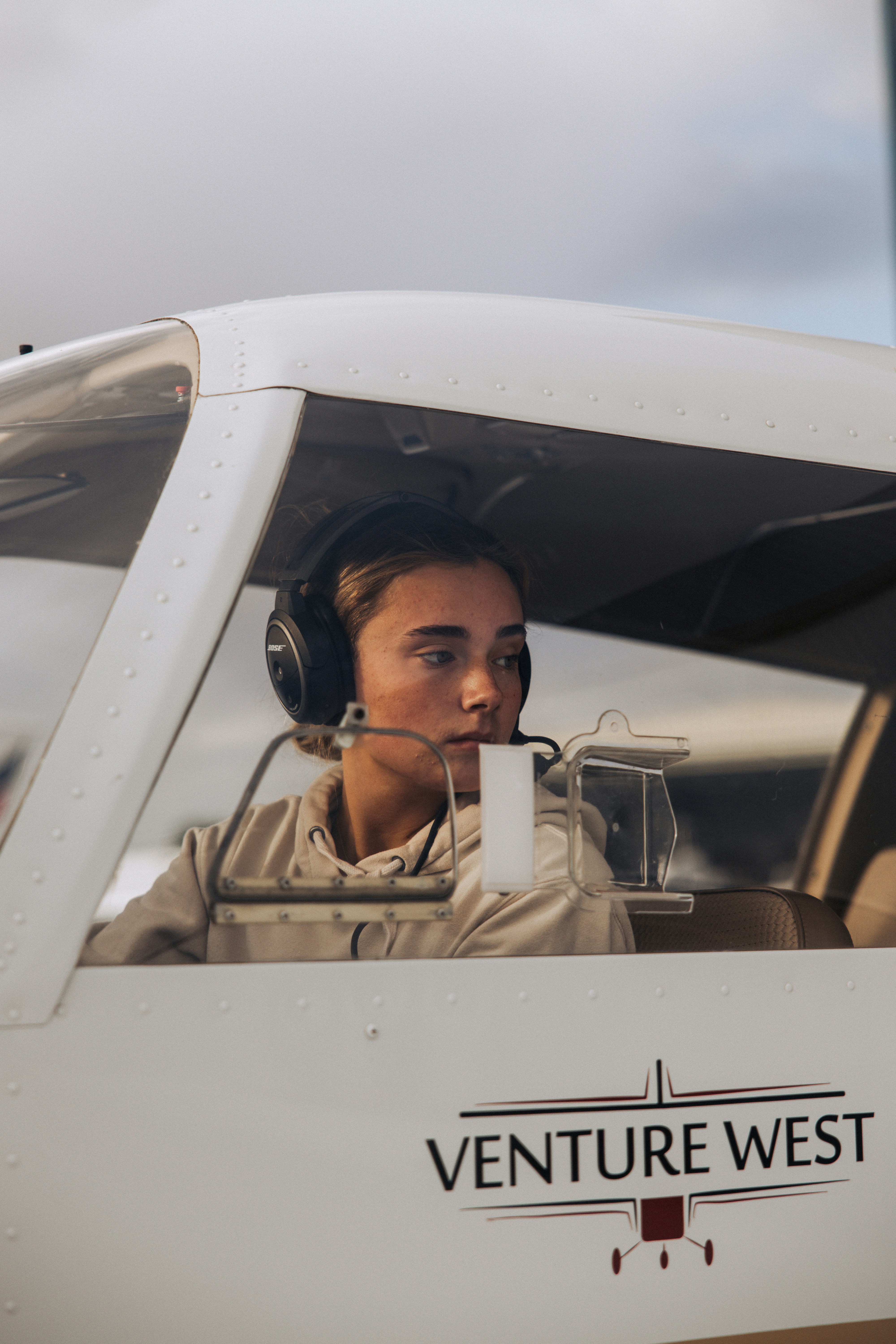 Junge Pilotin im Cockpit mit Headset im Cockpit