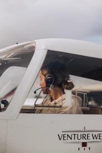 Young woman pilot wearing headset in cockpit