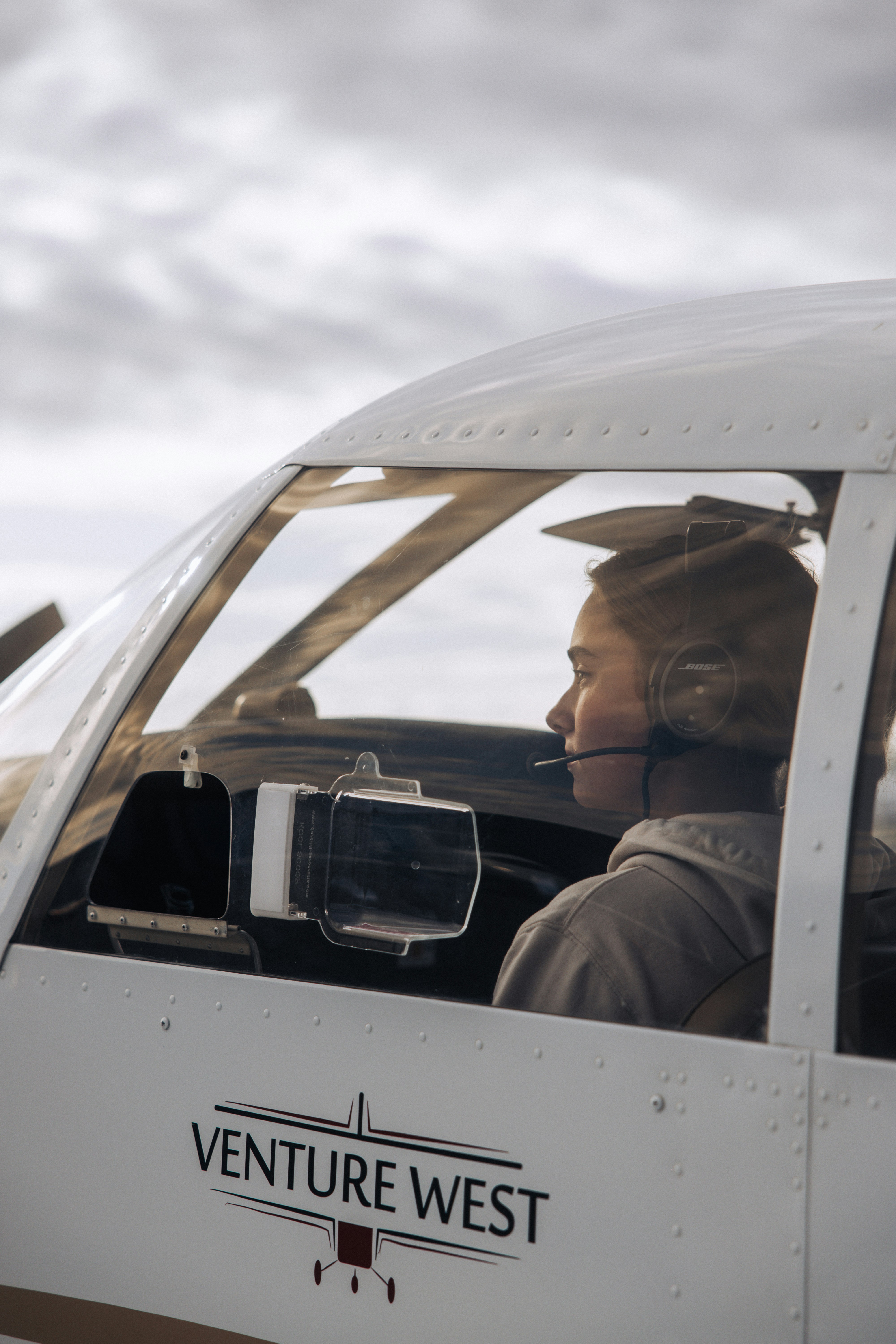 Young woman pilot in cockpit of small airplane