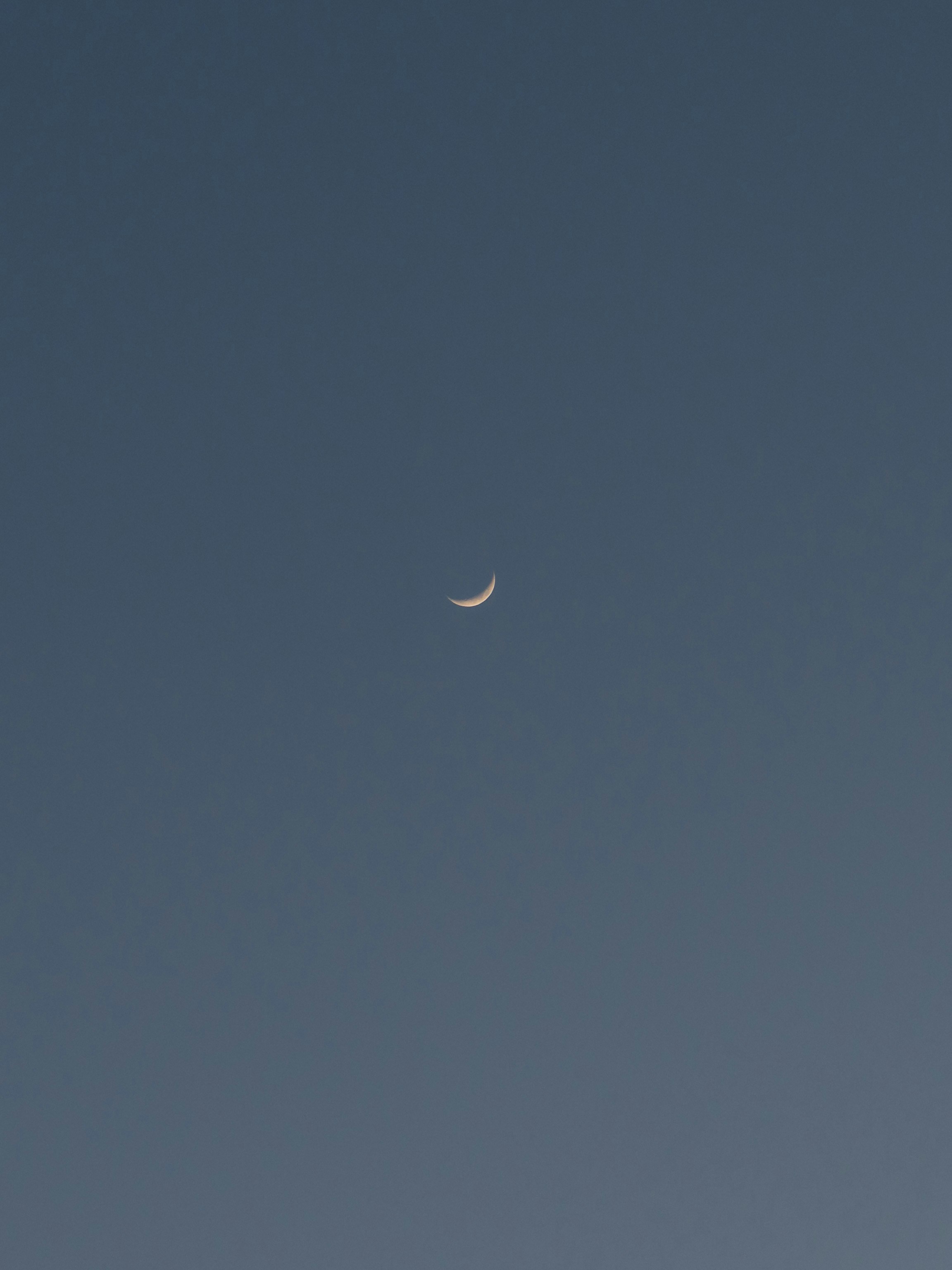 澄んだ青空に輝く三日月のような光景