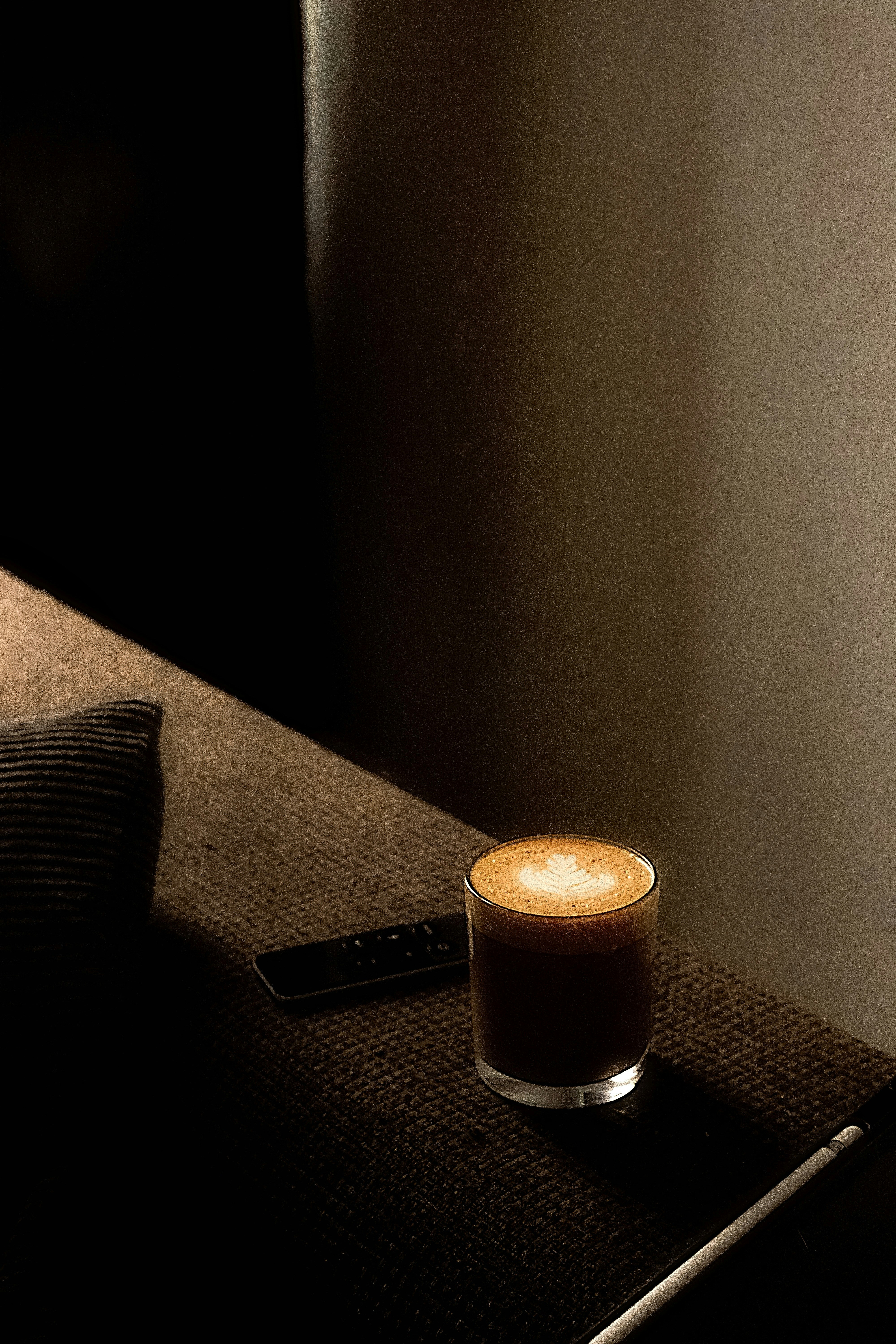 Un bicchiere di caffè con latte art su un tavolo.