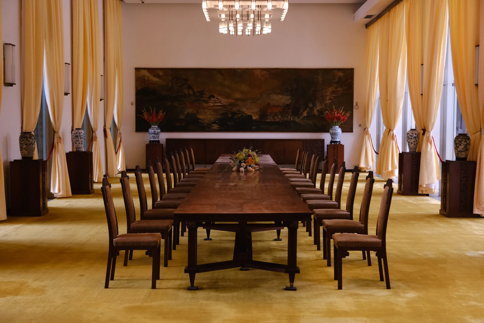 Long wooden boardroom table with chairs in a formal meeting room