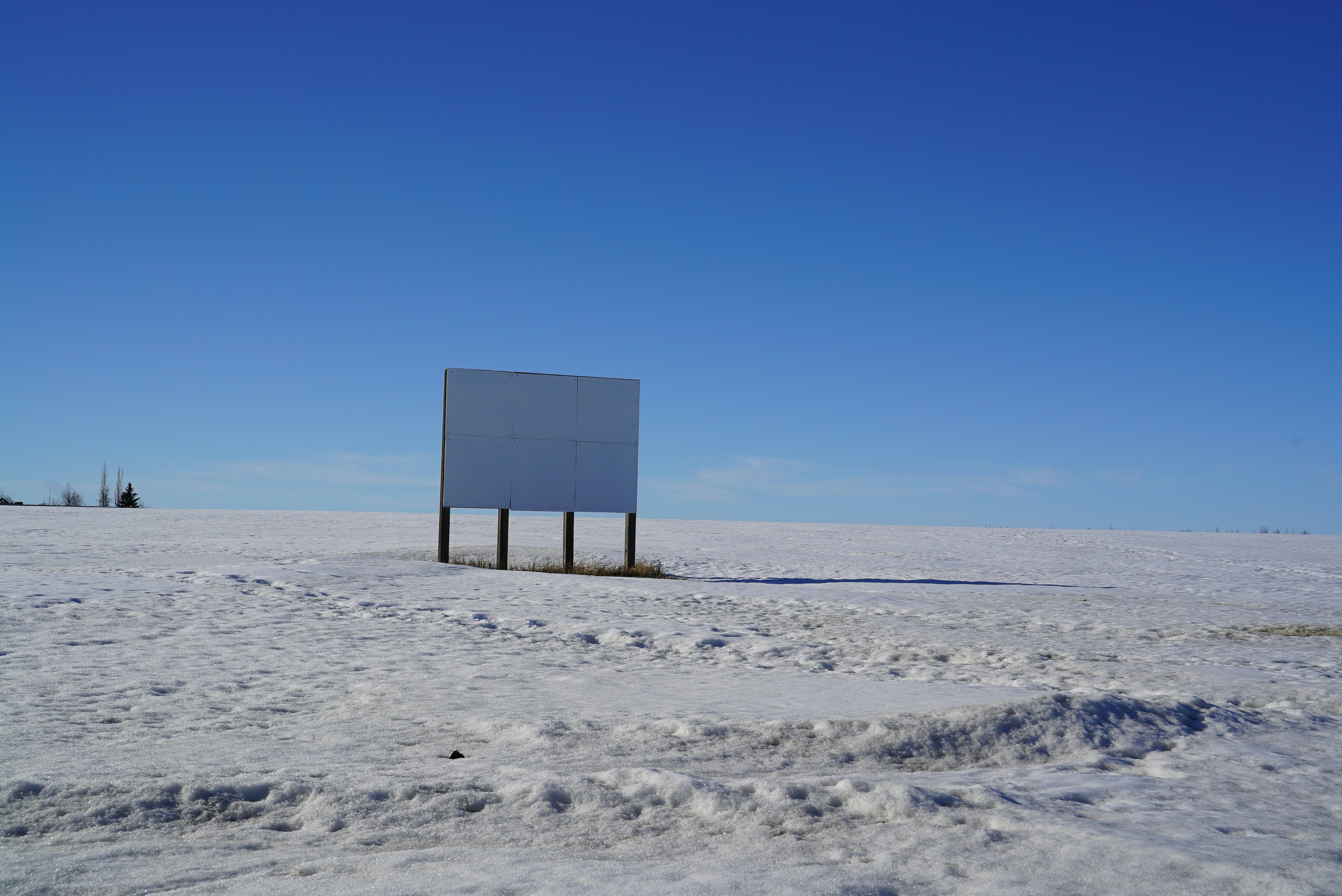 Blank billboard in a snowy, open field.
