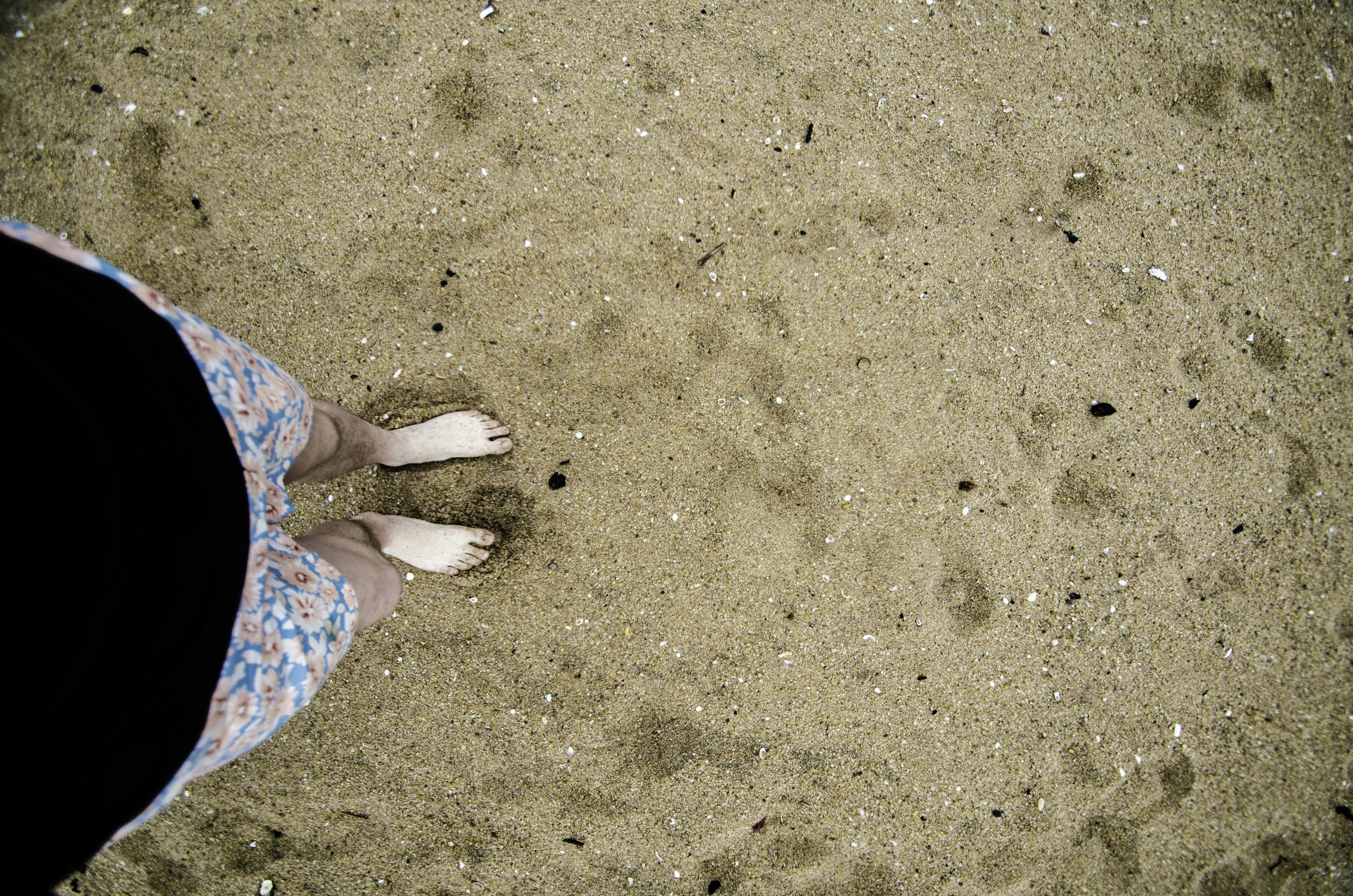 Piedi nudi in piedi su una spiaggia sabbiosa.