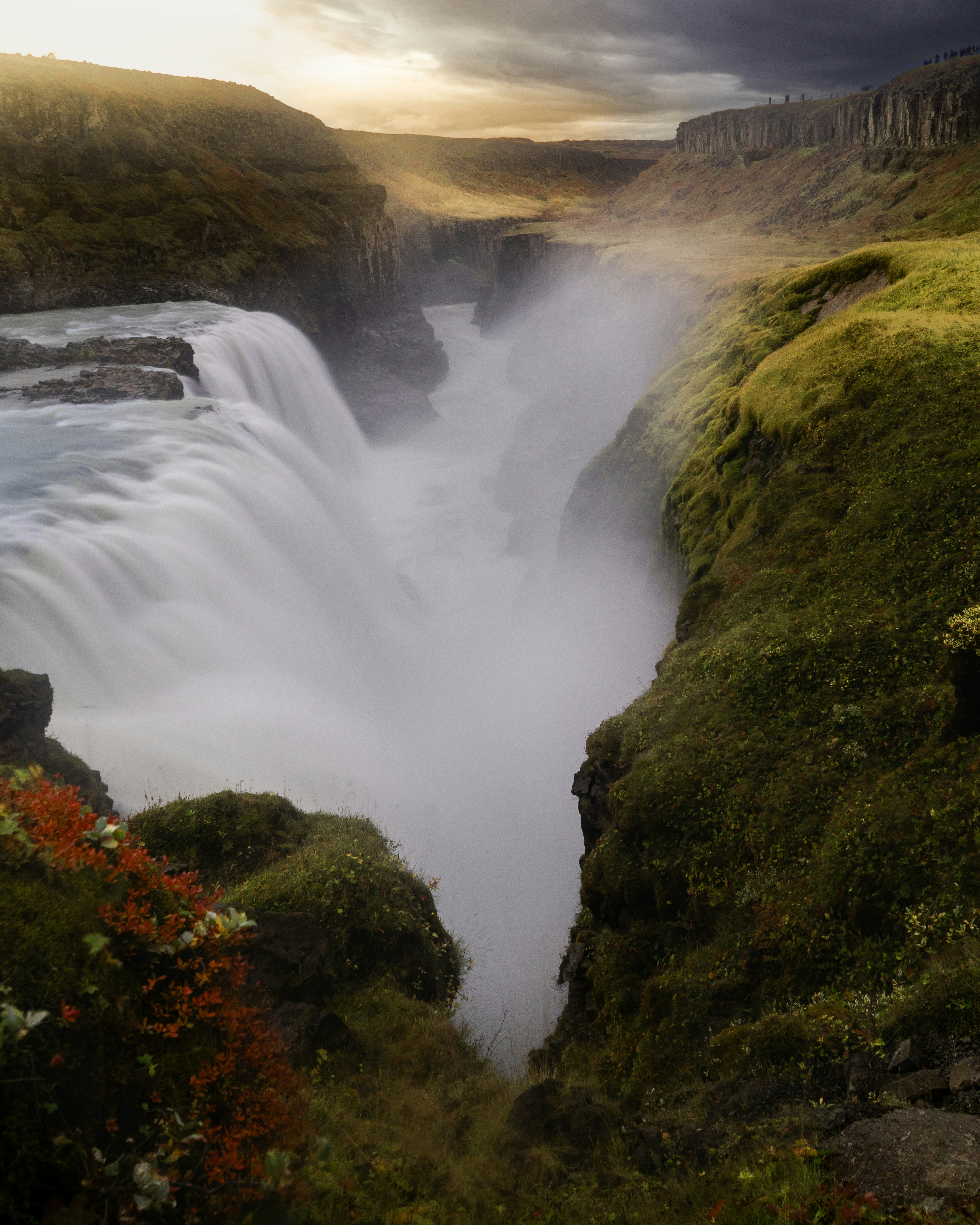 Misty waterfall cascading through a mossy canyon