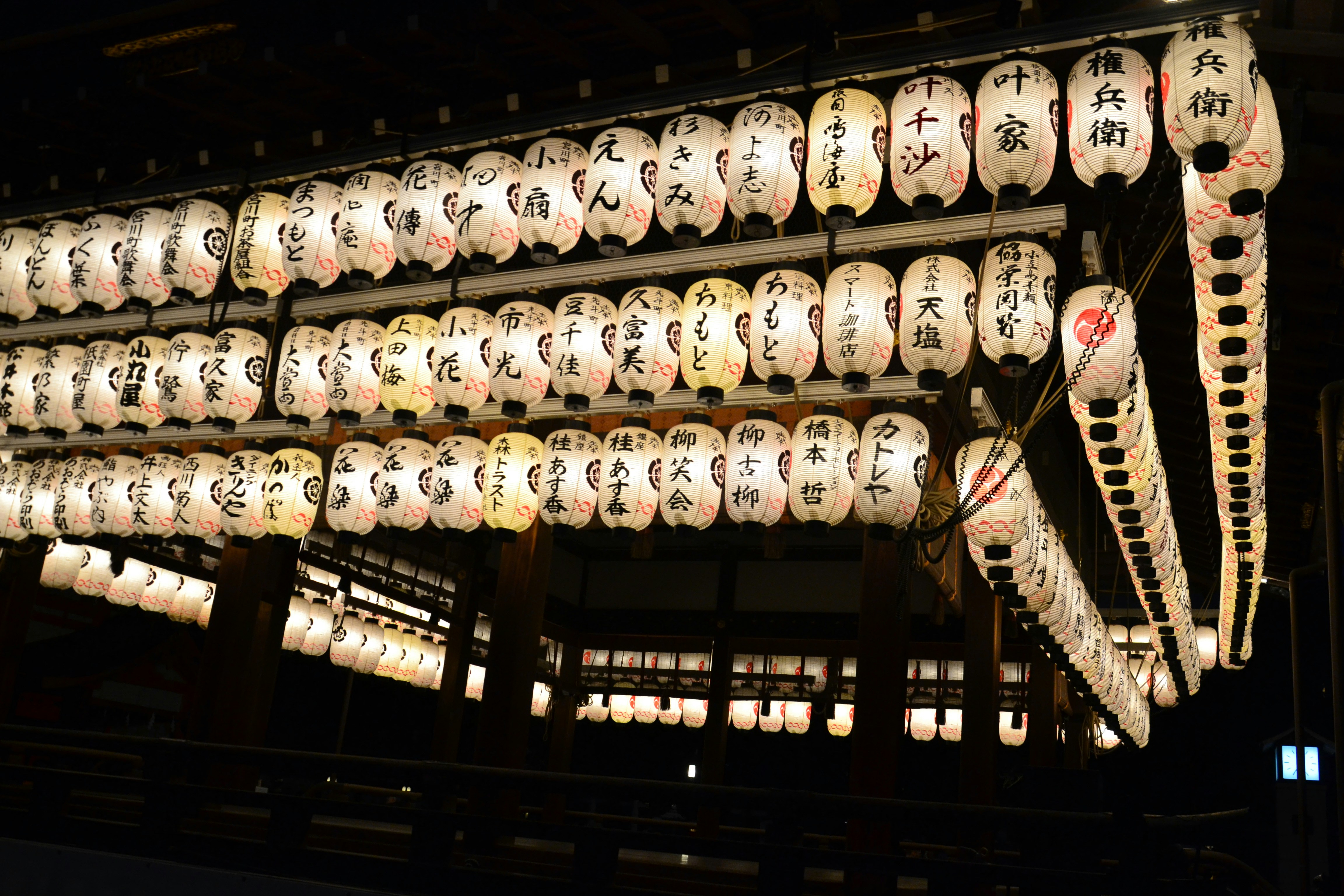 Rows of illuminated japanese lanterns hang indoors