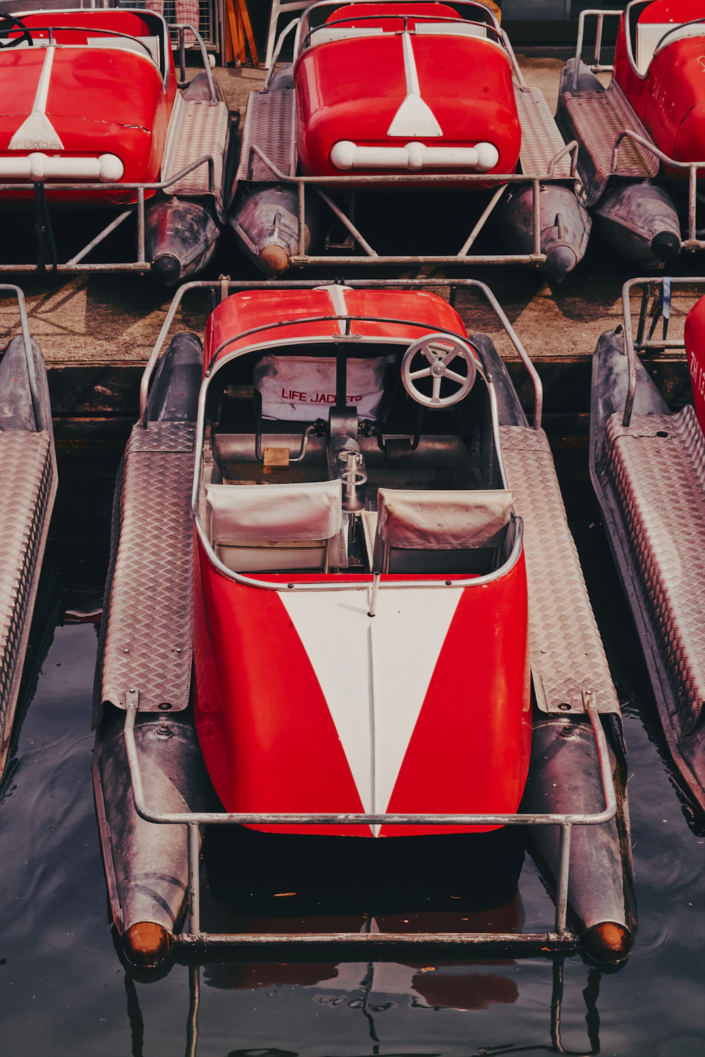 Red pedal boats docked on the water