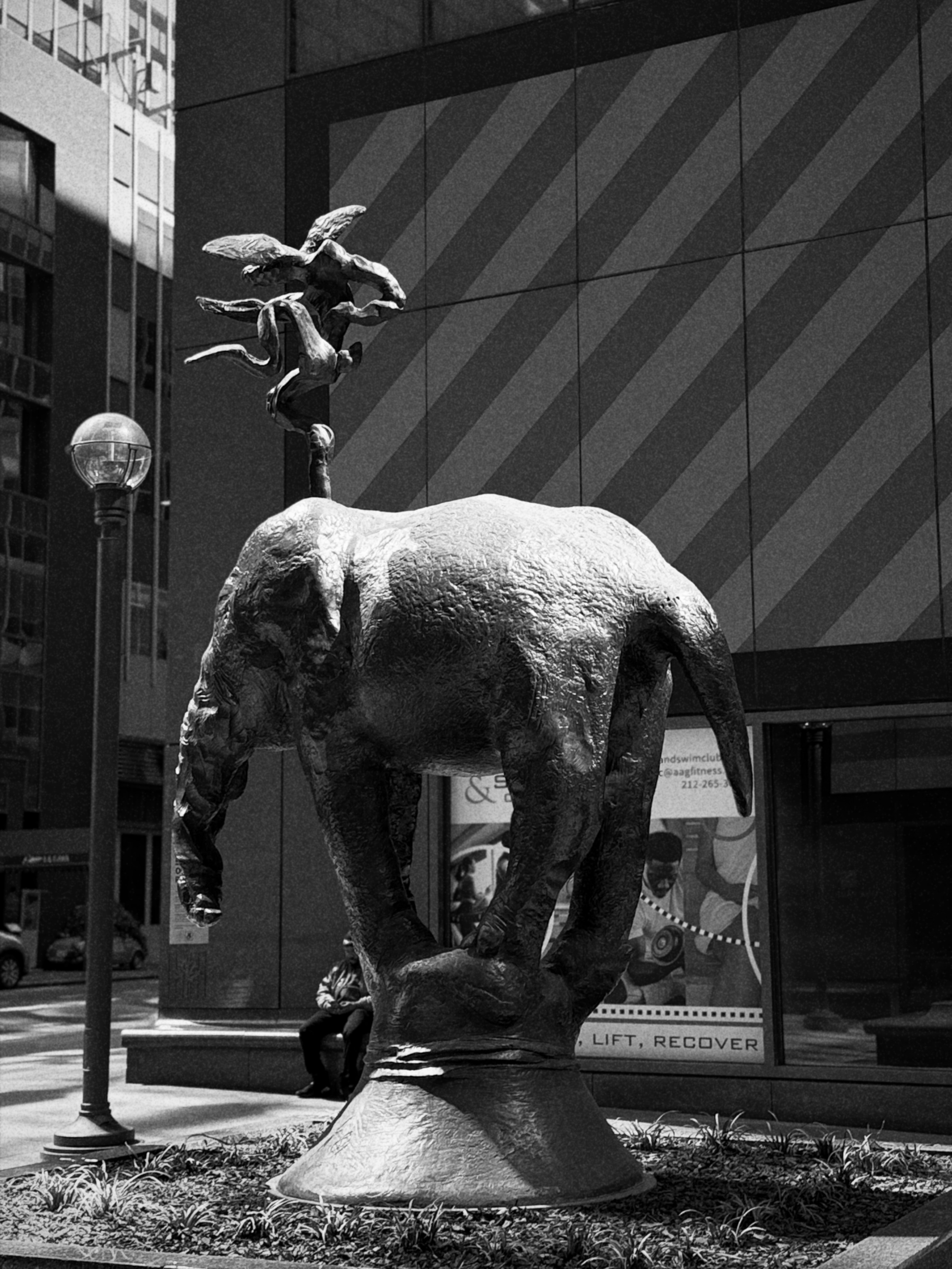 Elephant sculpture with figures on top in city