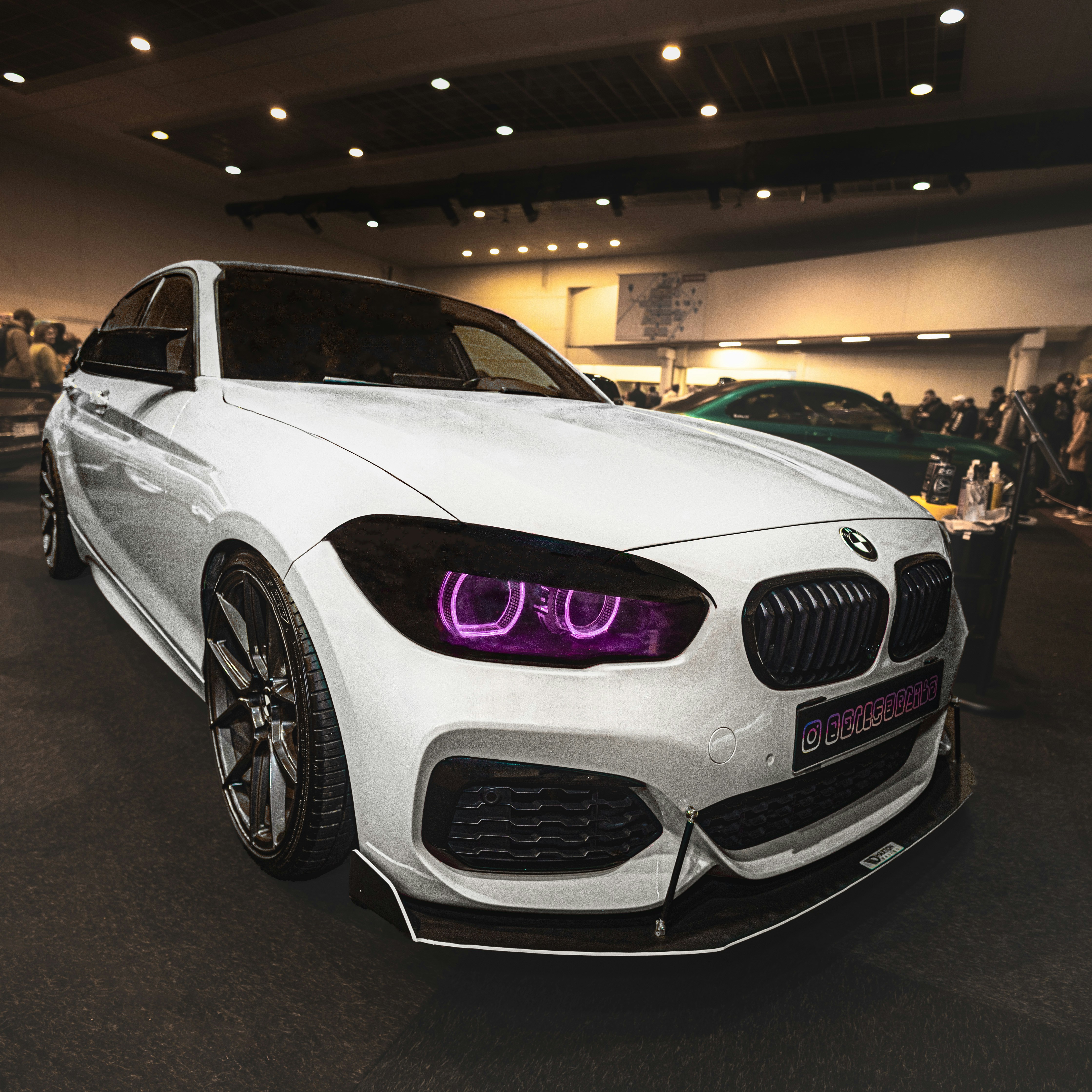Weißer BMW mit lila Halo-Scheinwerfern auf der Autoshow