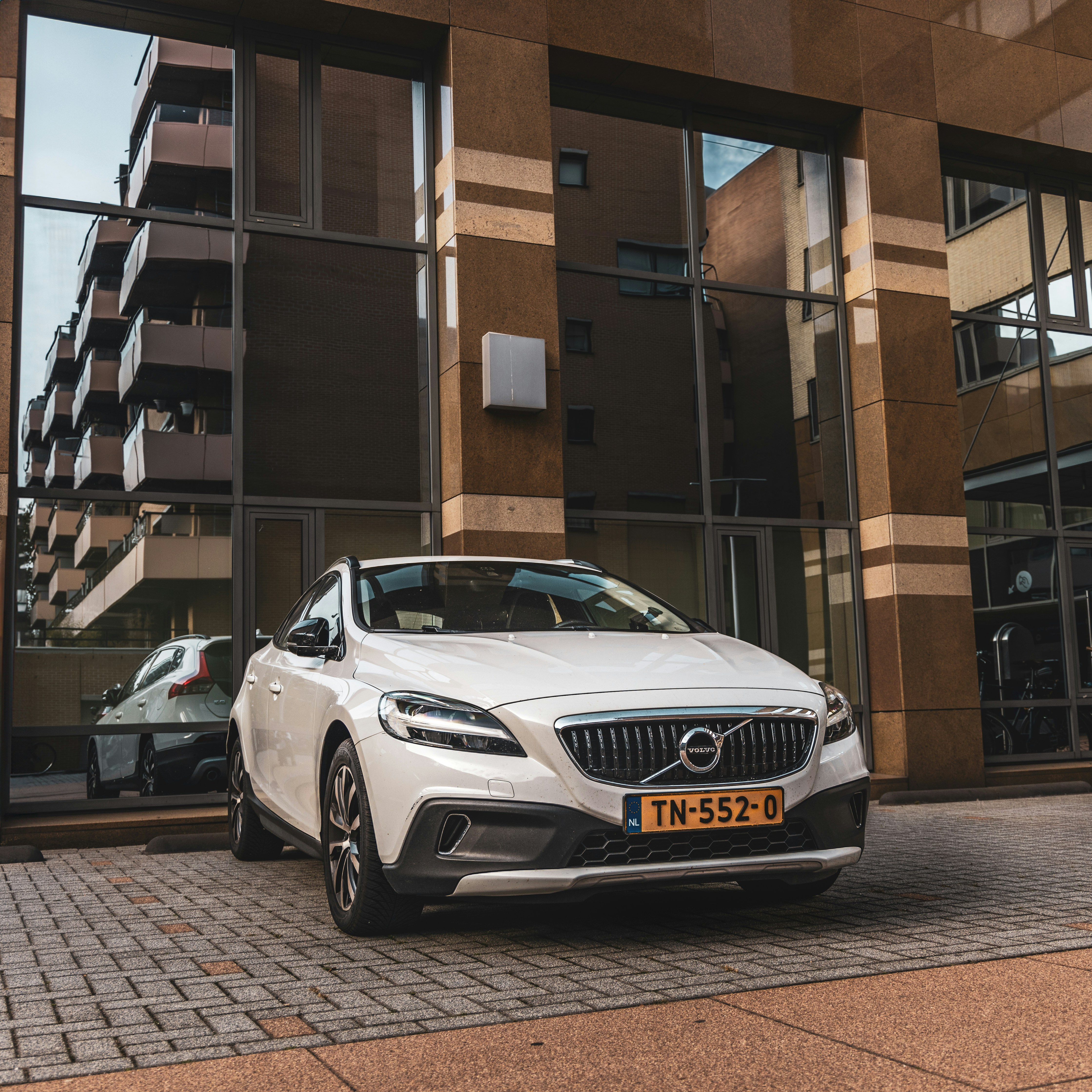White volvo parked outside modern building