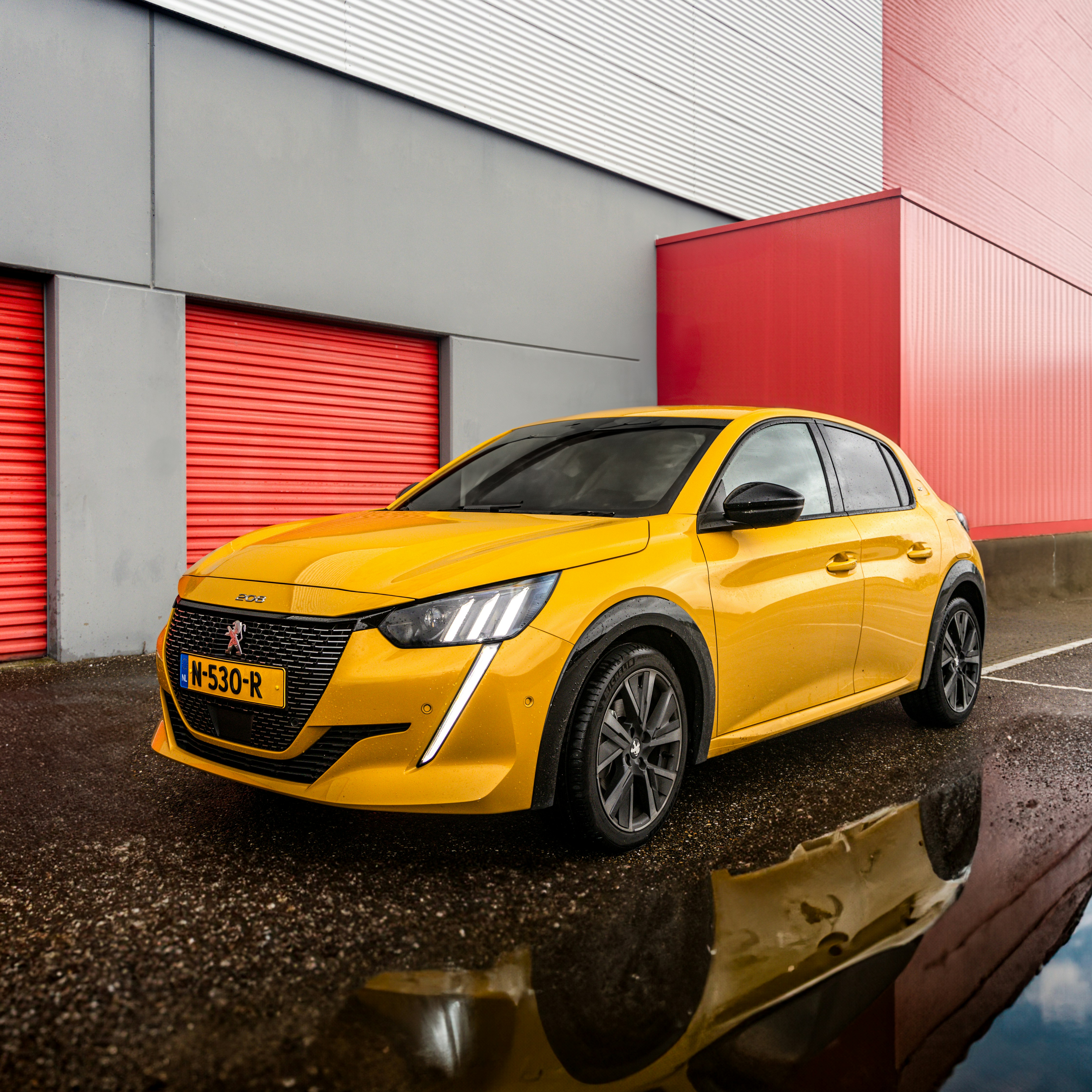Yellow peugeot 208 parked outside modern building