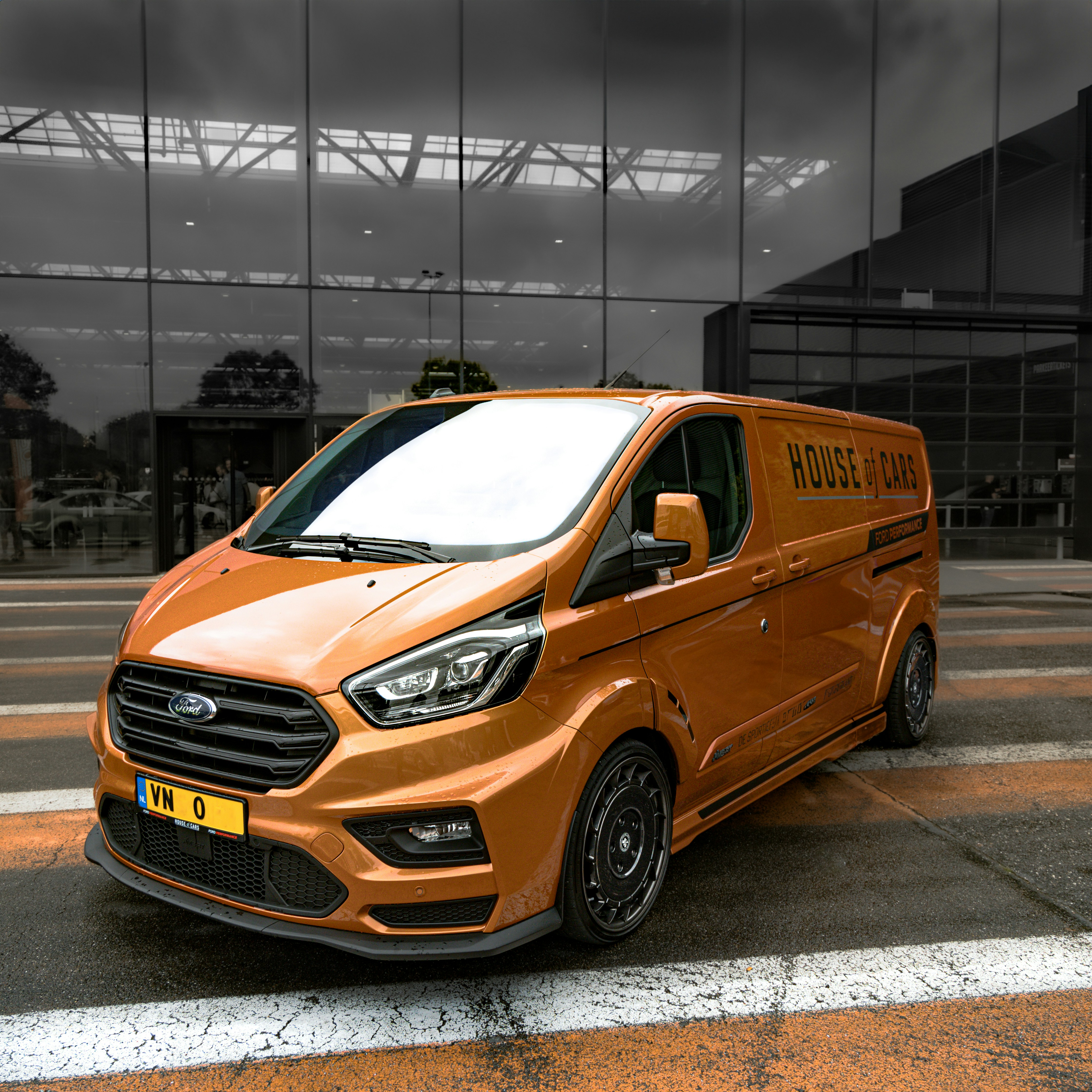 Custom orange ford transit van parked outside building