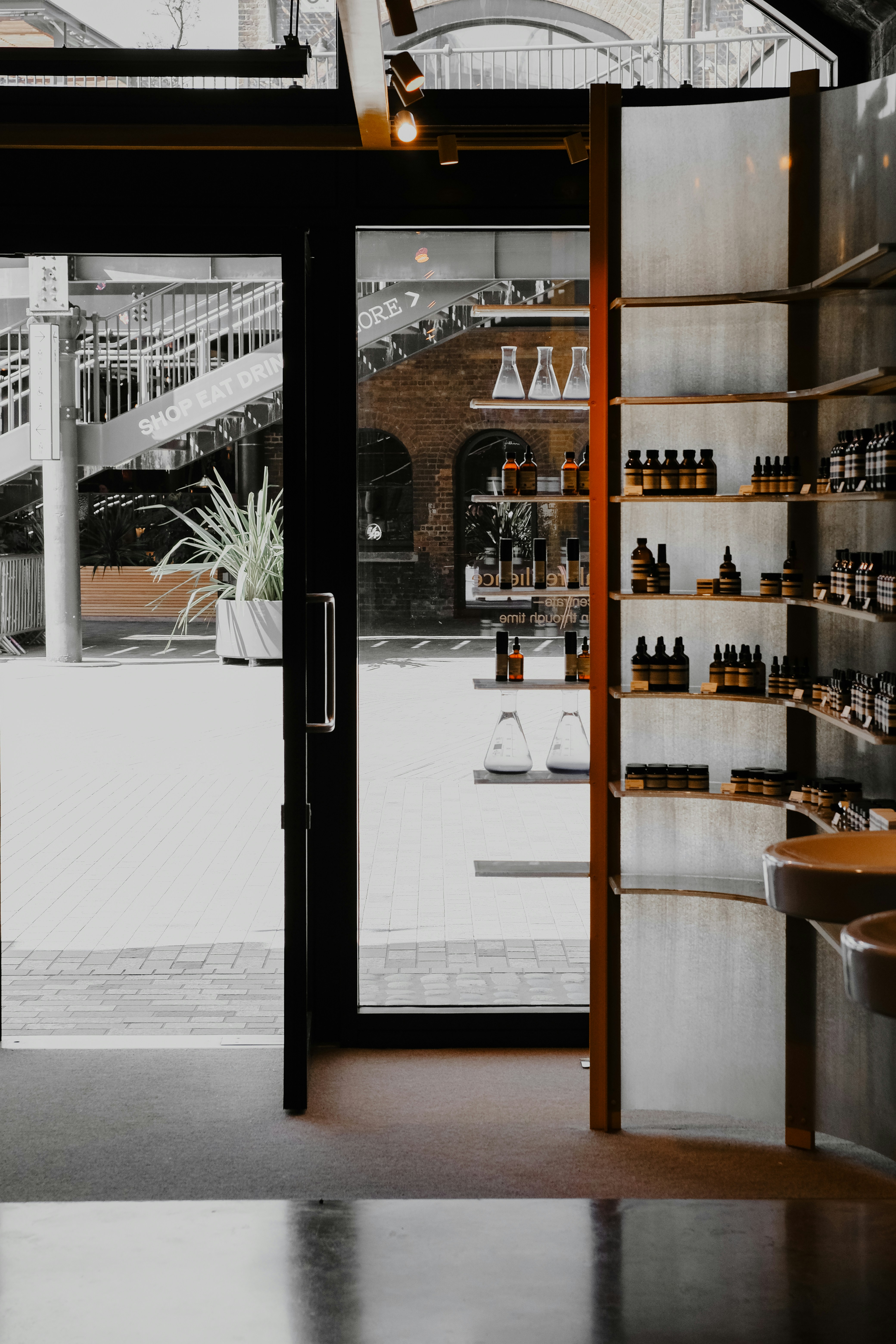 Store interior with shelves of bottles and sinks.