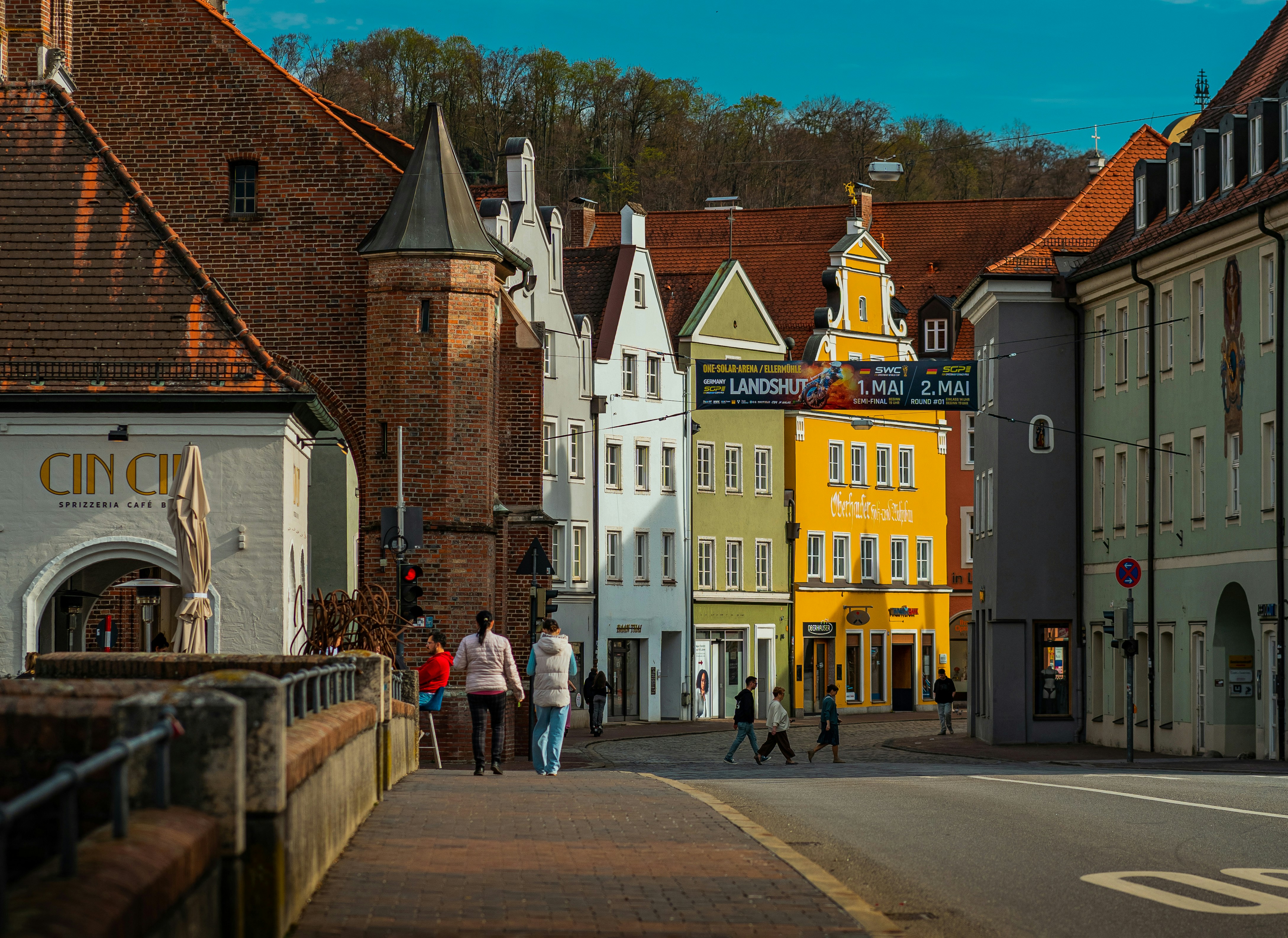 colorful buildings line a street with people walking
