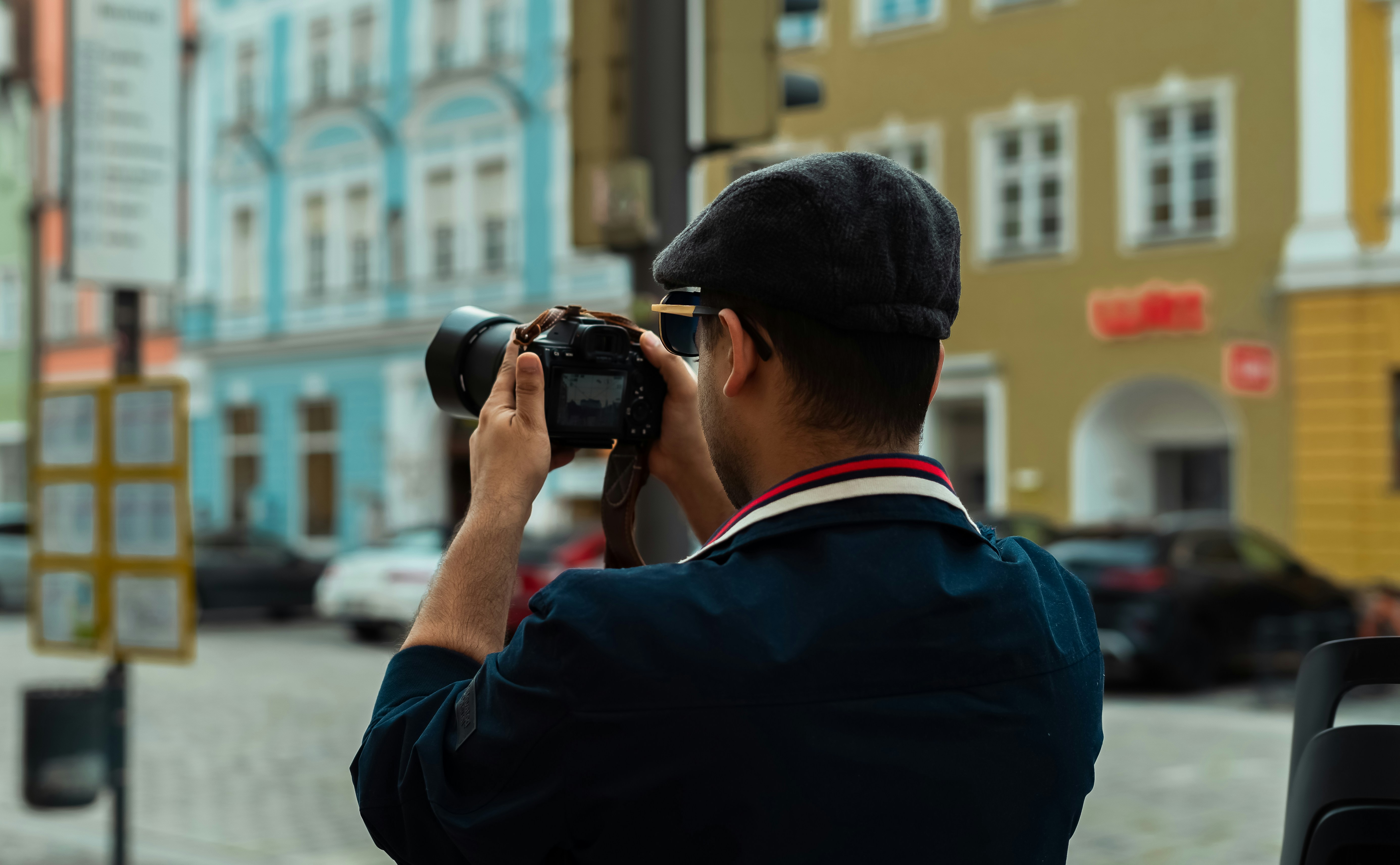 Uomo con il berretto che fa una foto con una macchina fotografica