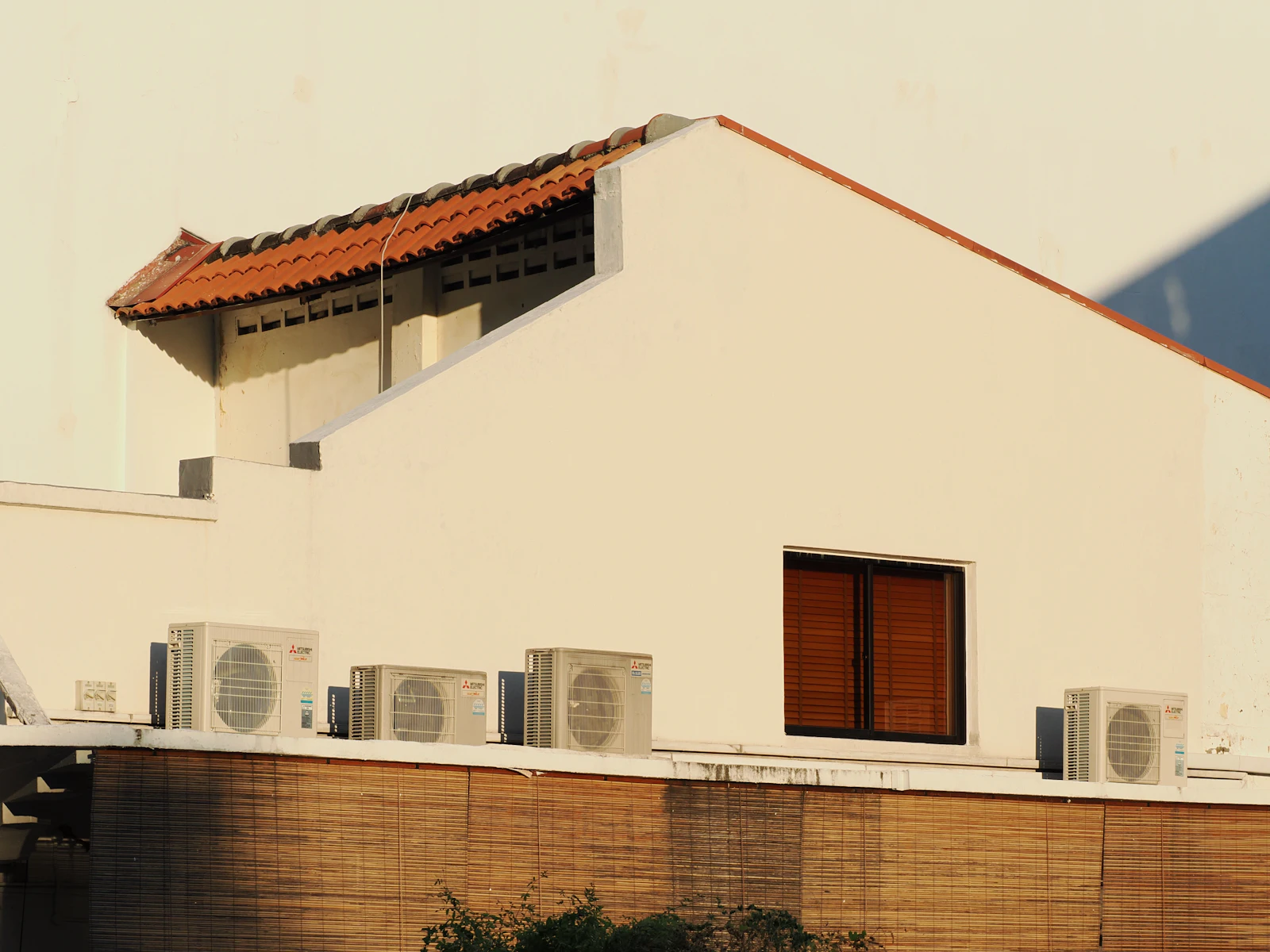 Large rooftop air conditioning units installed in a row on a commercial building roof