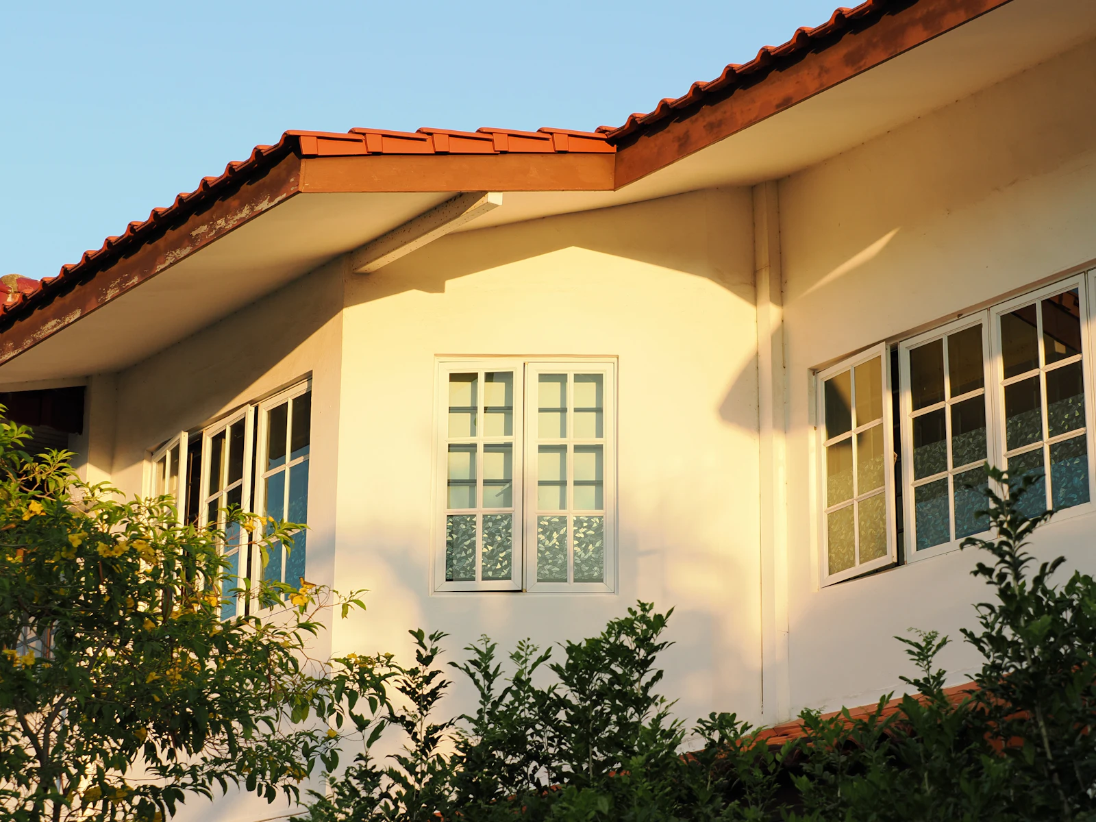 White house with a red tiled roof and gutters