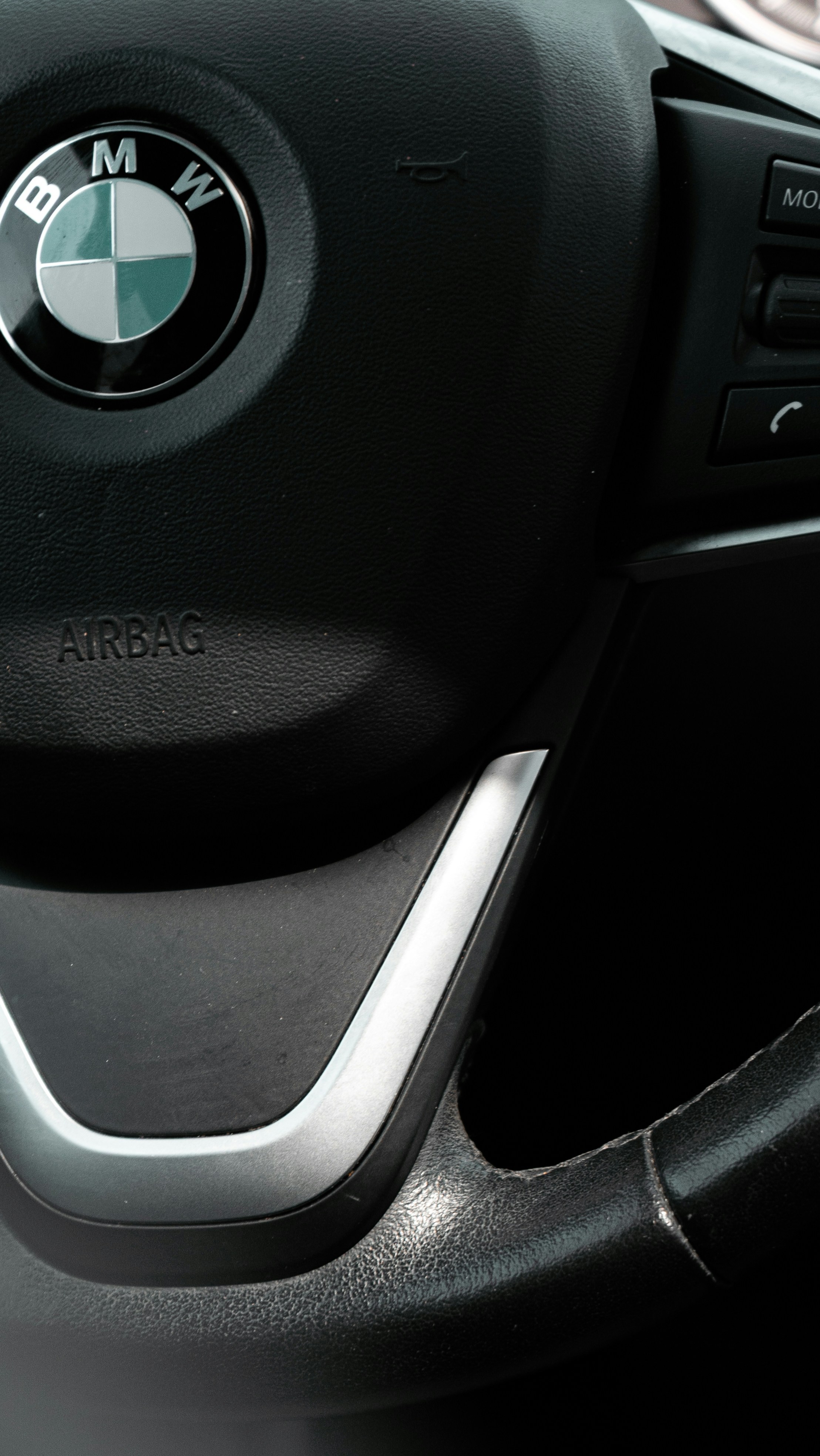 Close-up of a BMW steering wheel with logo.