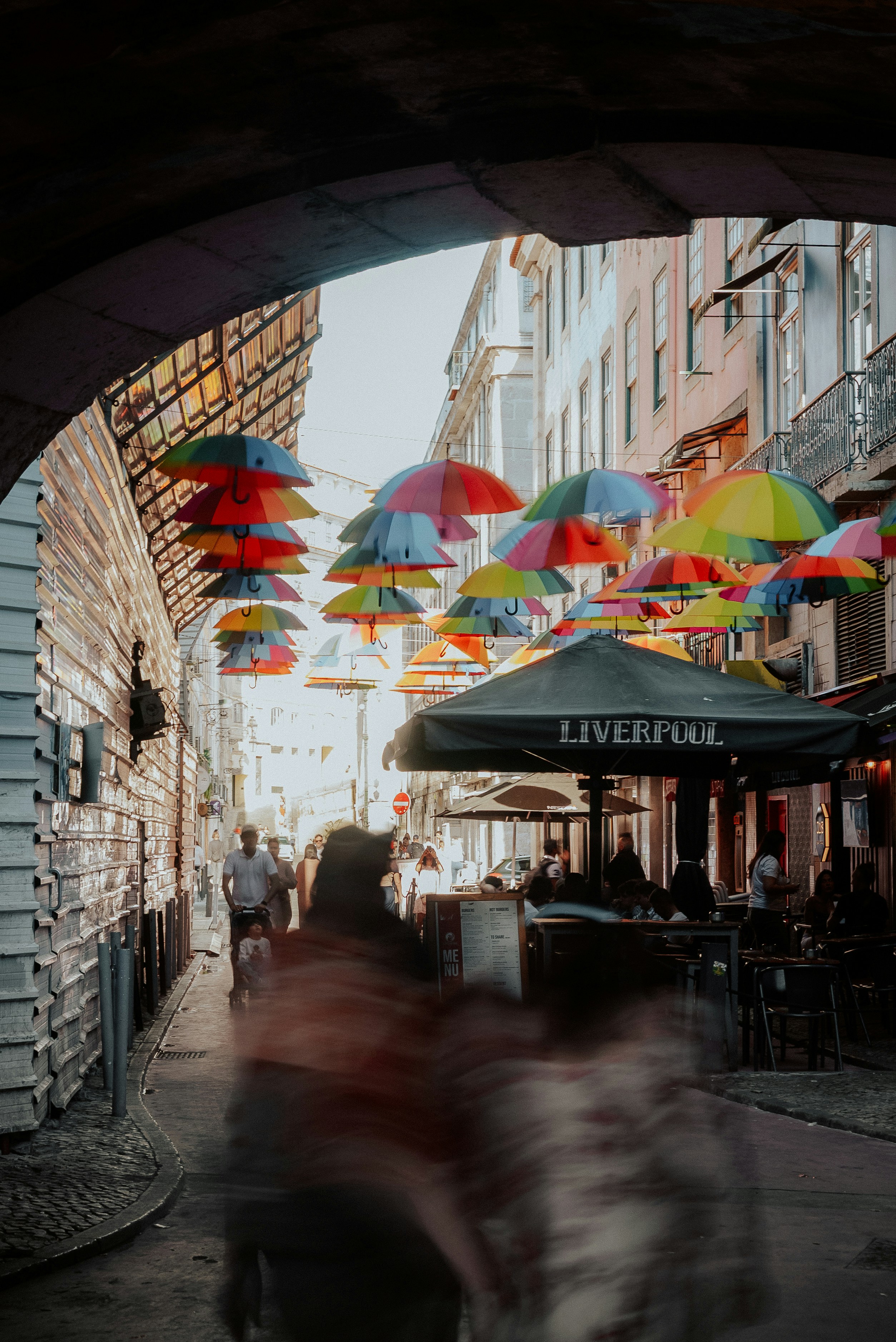 Colorful umbrellas suspended over a bustling city street.