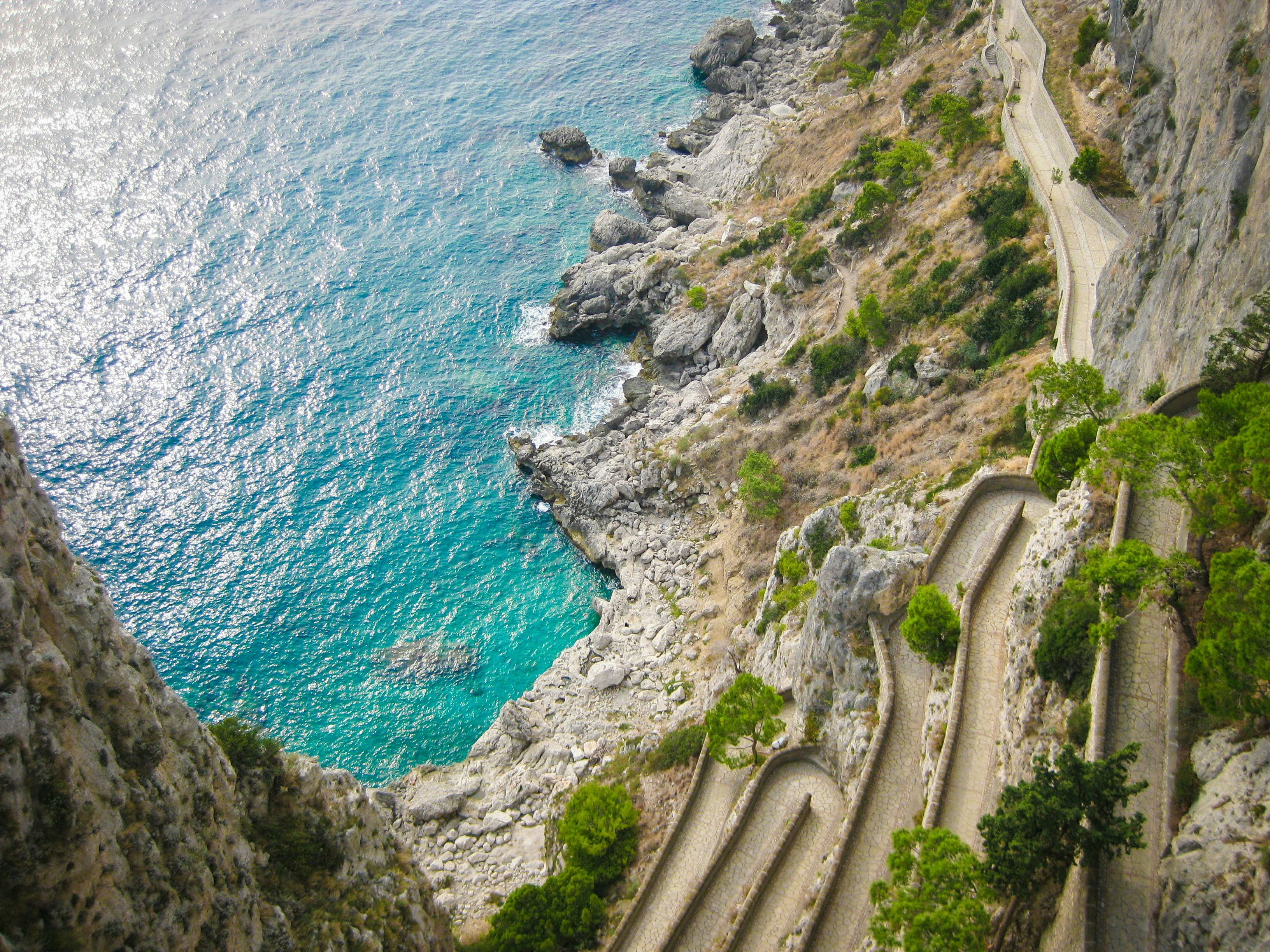 Winding road along a cliff overlooking the turquoise sea.