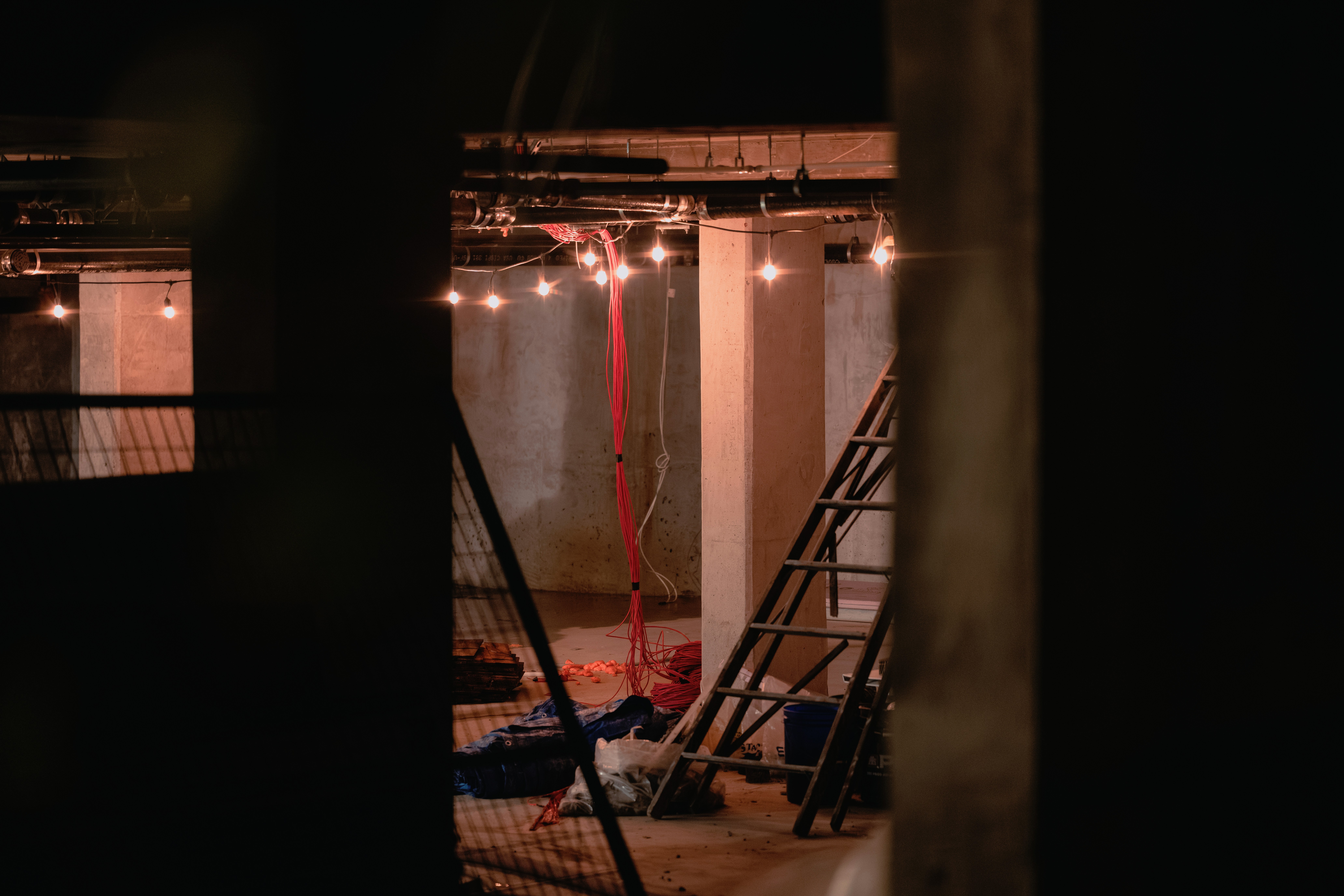 Construction site with ladders and dangling wires.