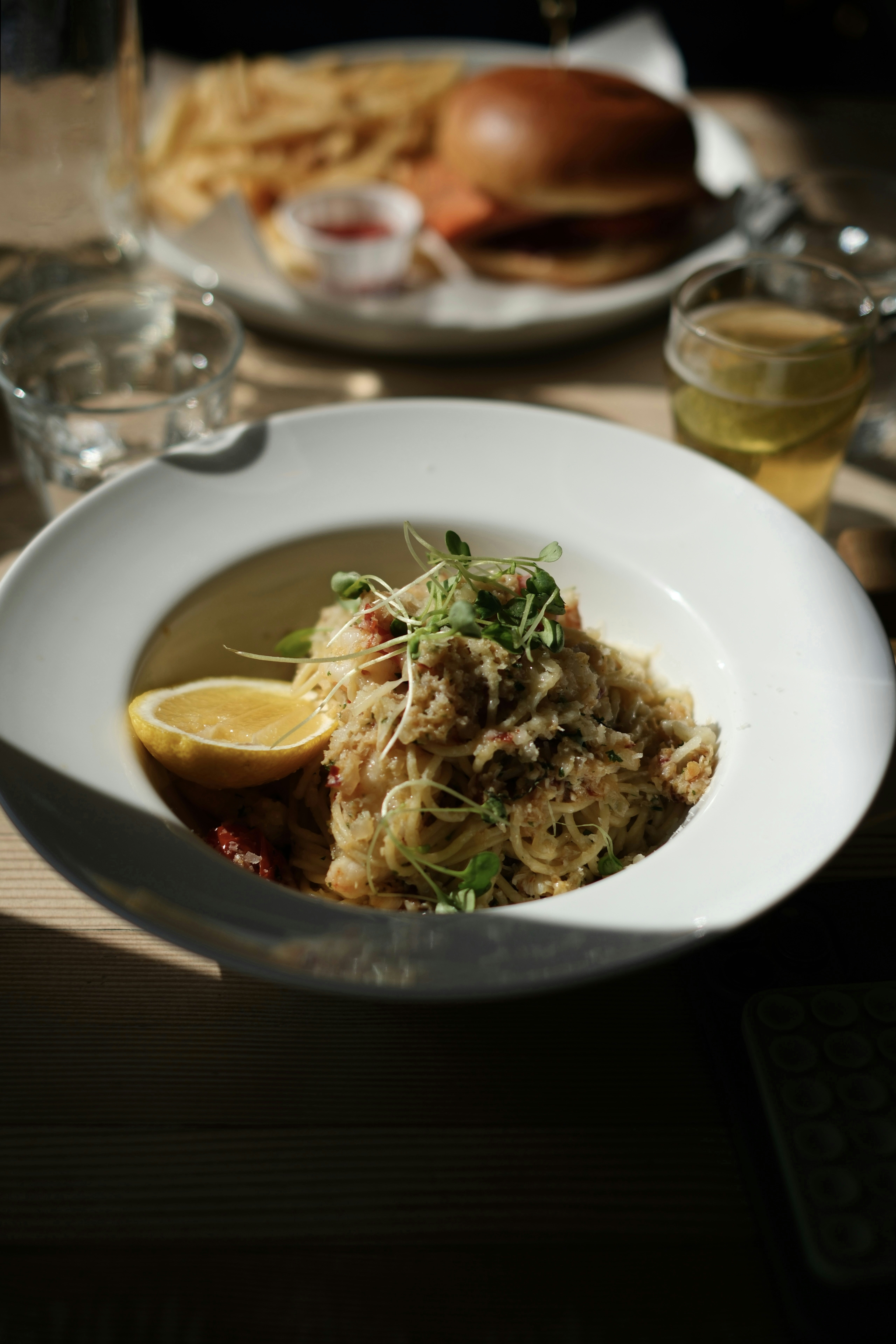 Crab pasta with lemon and microgreens served with fries.