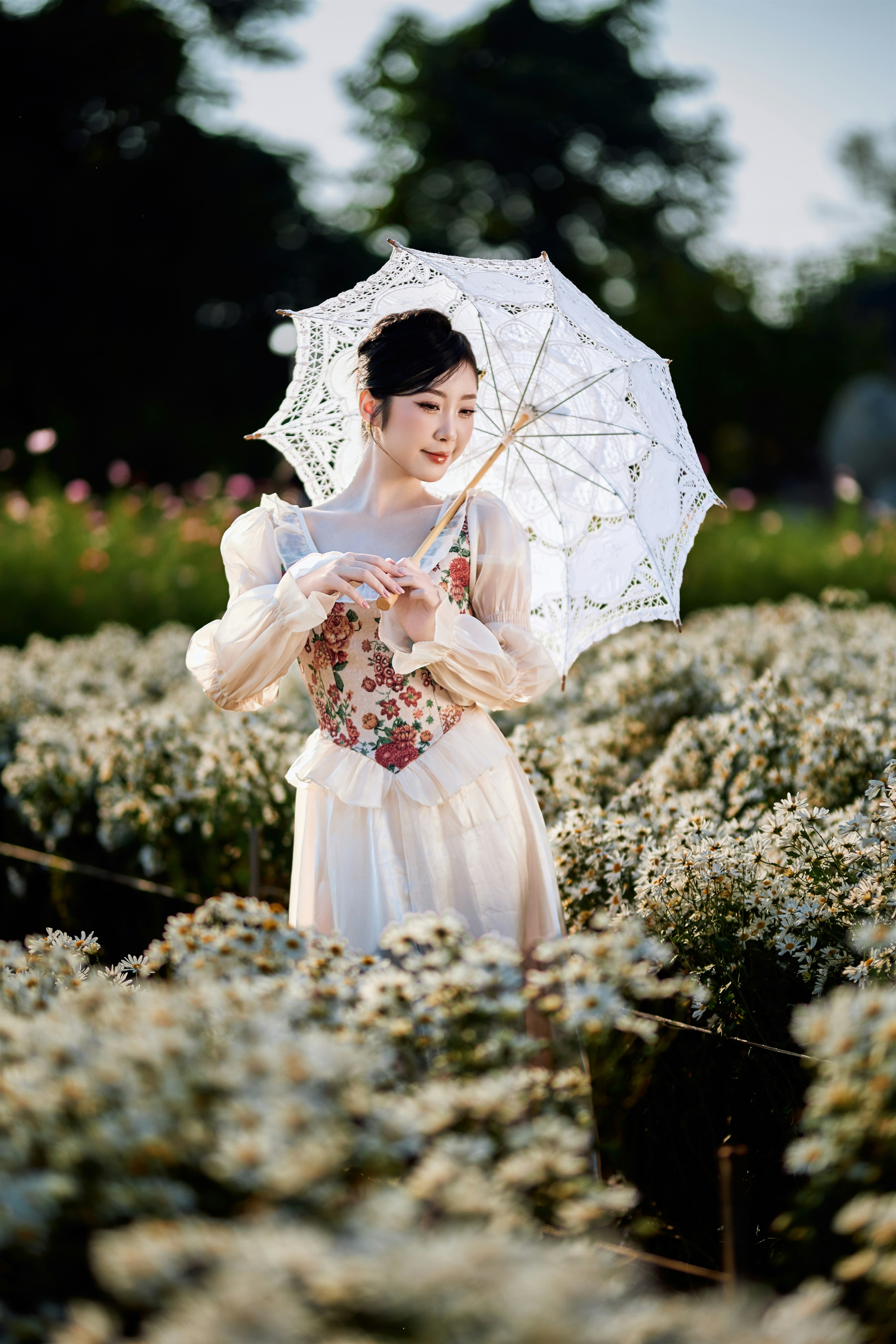 Woman in vintage dress holding lace umbrella amidst flowers
