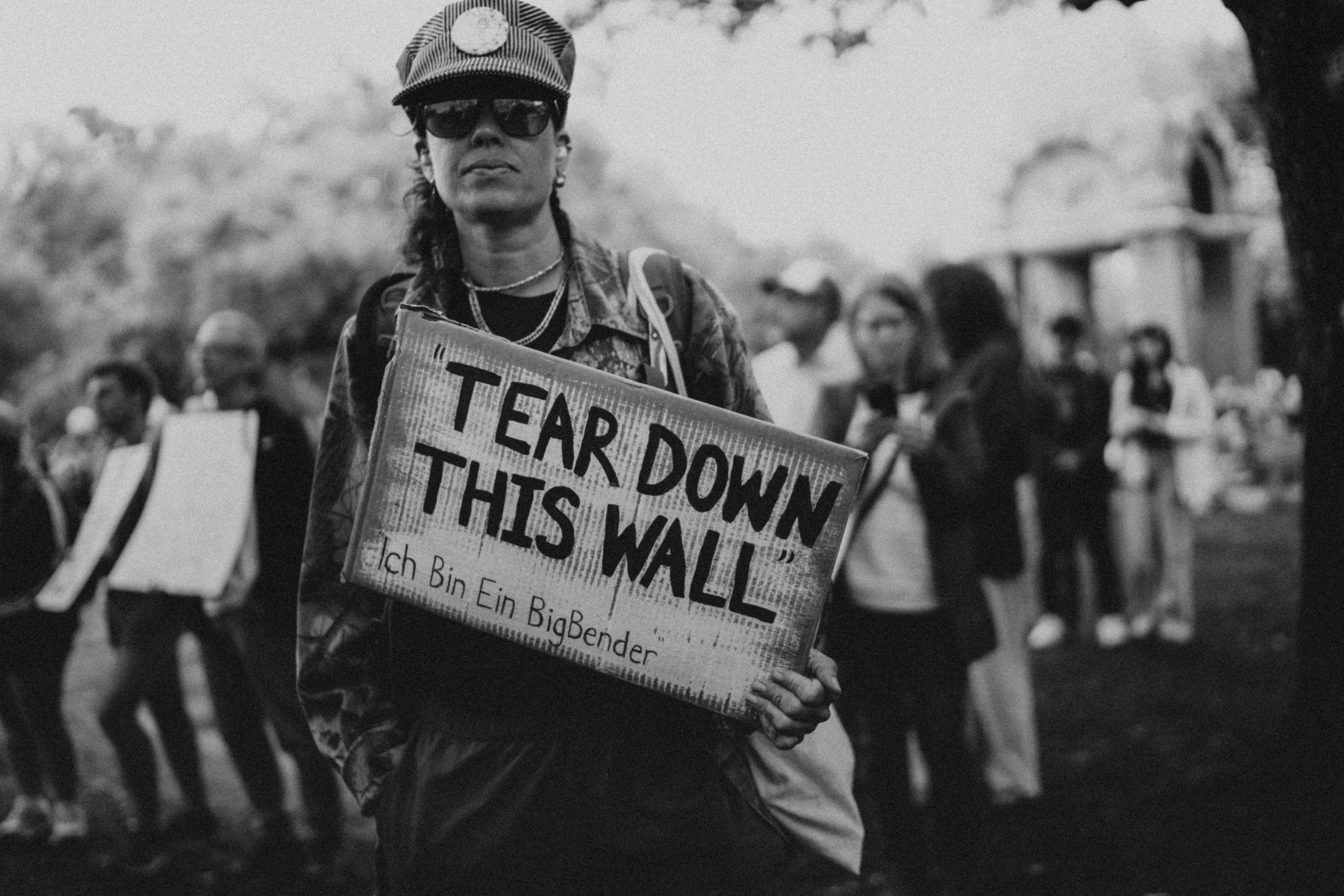 Man holds sign saying "tear down this wall"