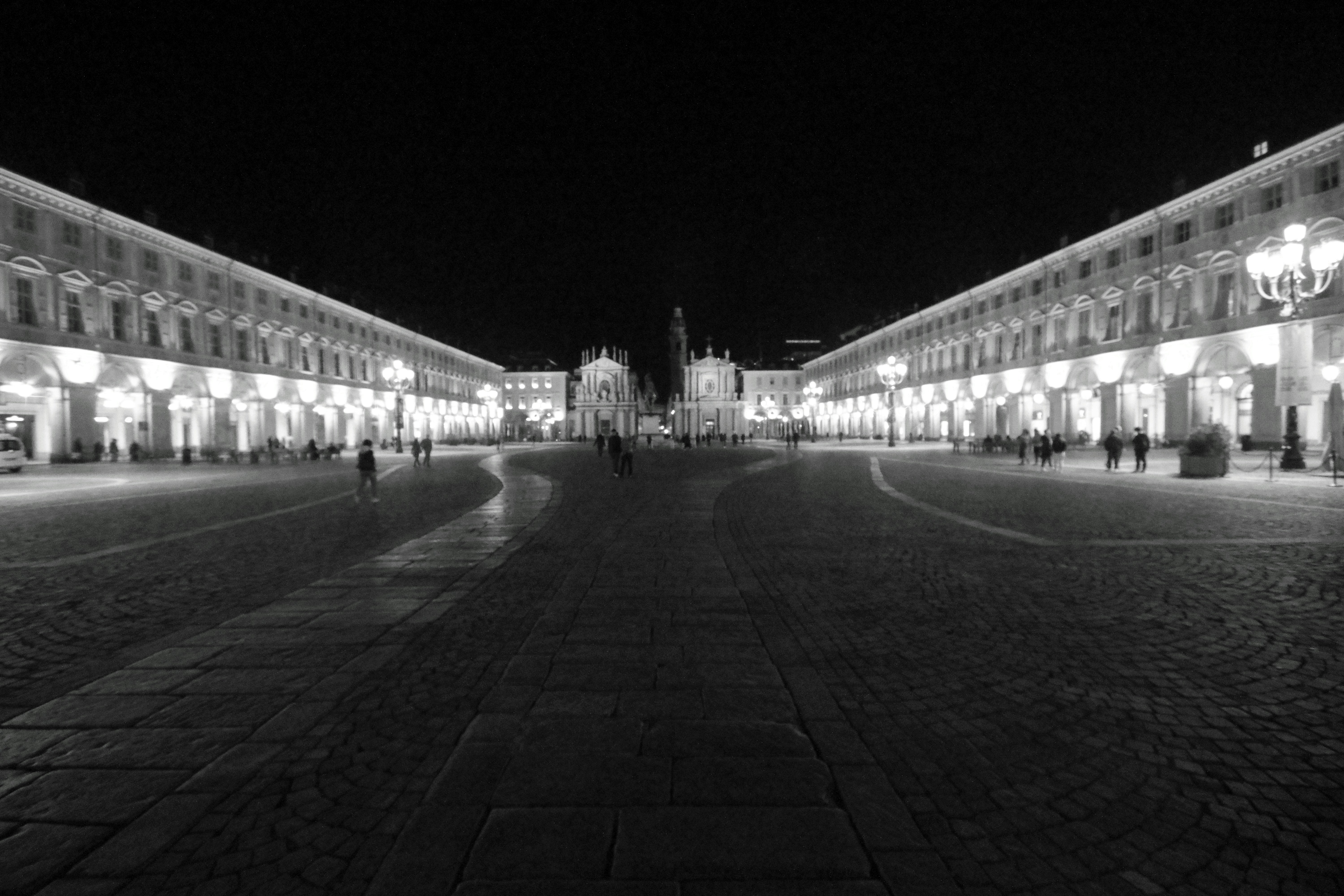 Grand illuminated square at night with symmetrical buildings.