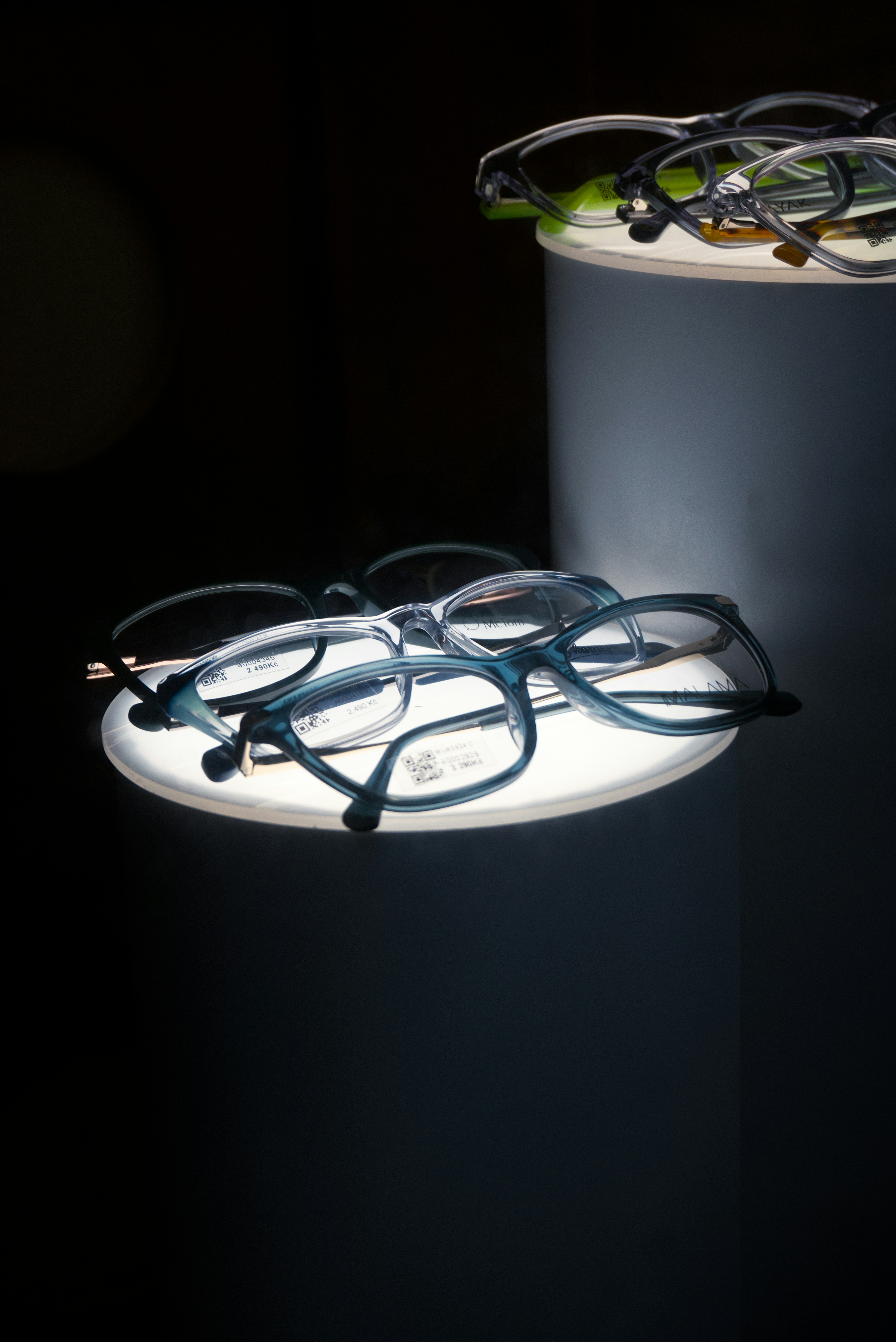 Varios pares de gafas en una pantalla iluminada.