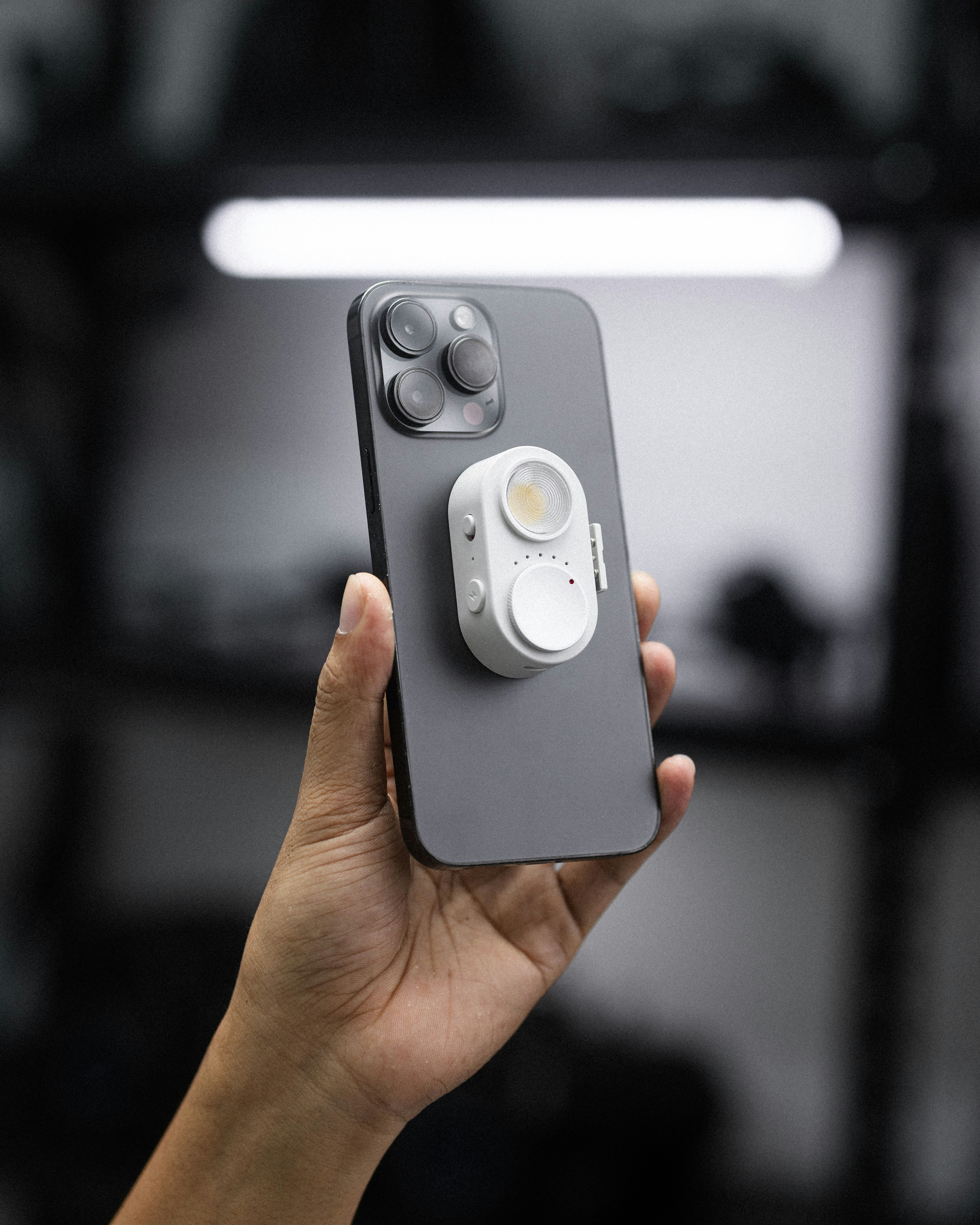 Smartphone de la mano con mini luz LED adjunta