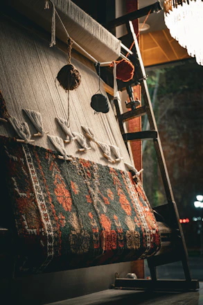 A partially woven rug on a loom