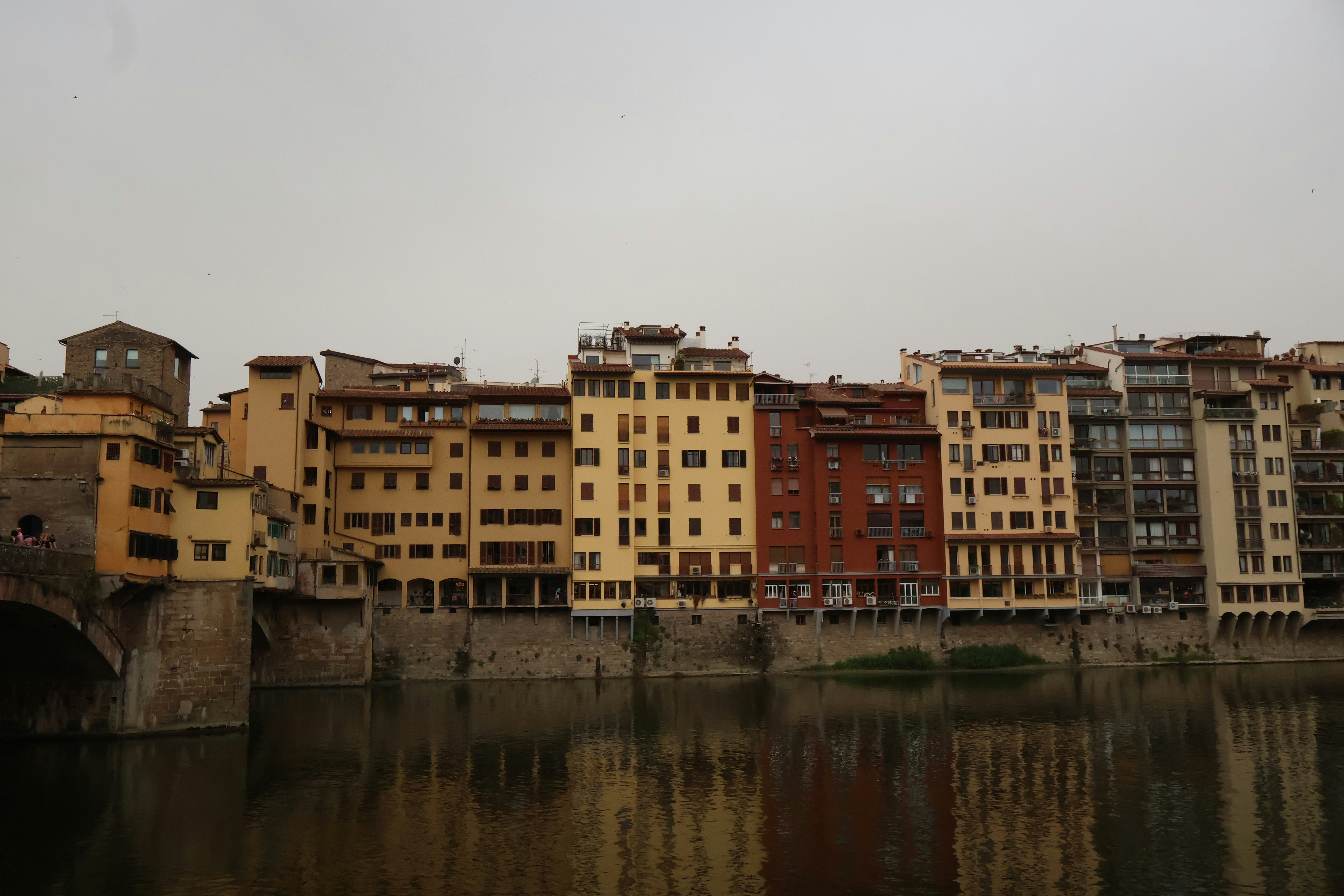 Edificios históricos bordean un río con reflejos.