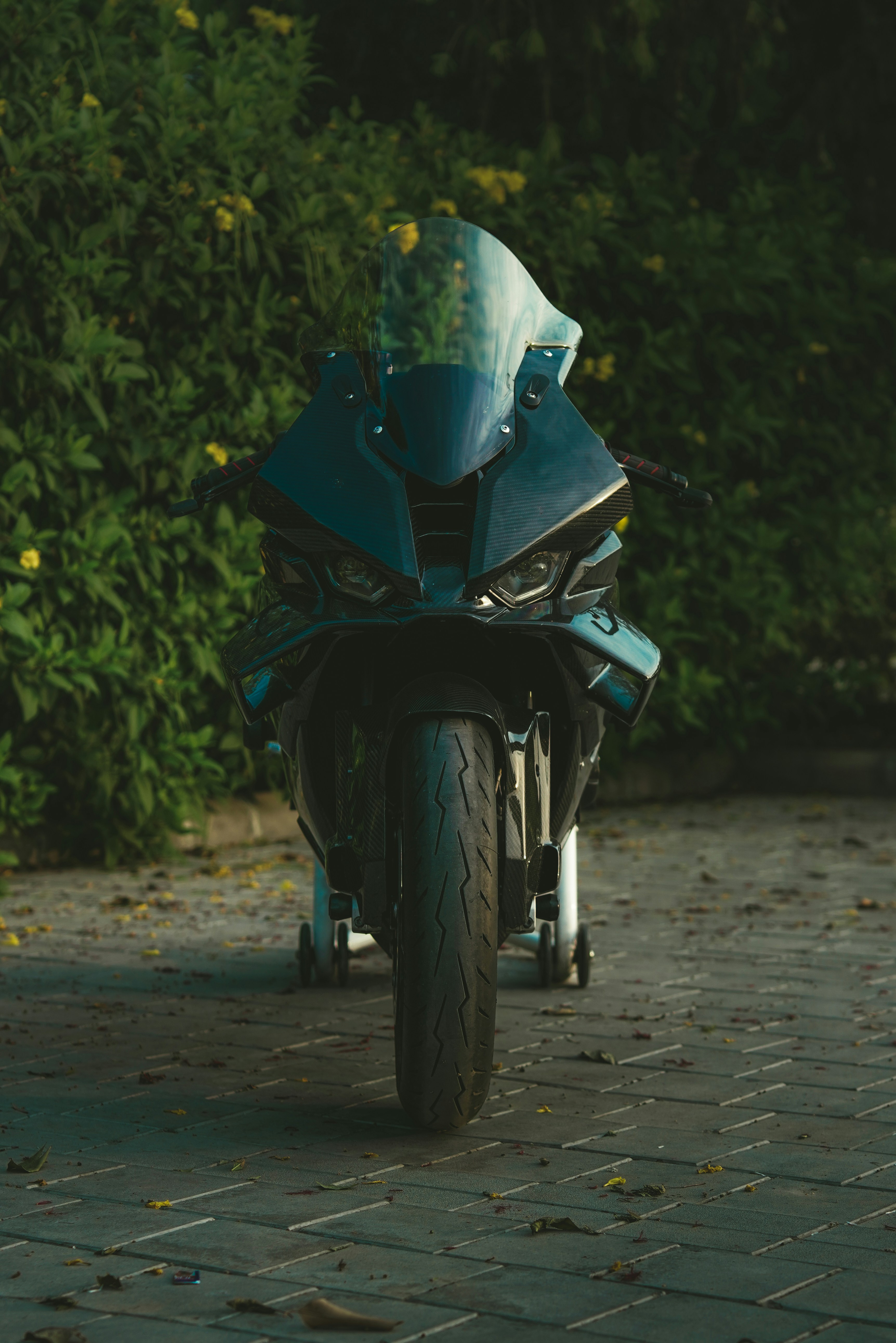Uma motocicleta esportiva preta estacionada em um caminho de tijolos.