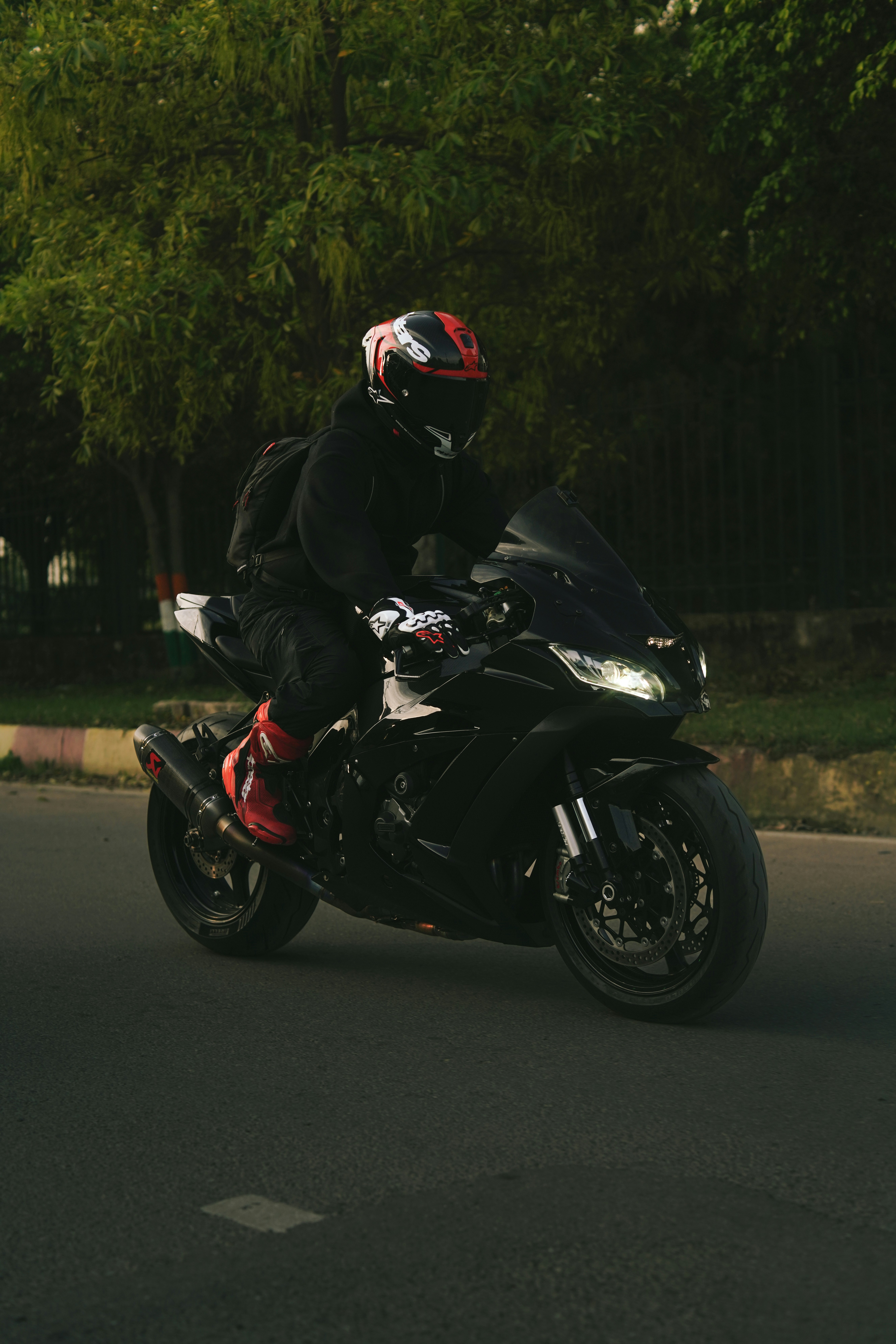 Uma pessoa pilotando uma motocicleta preta numa estrada.