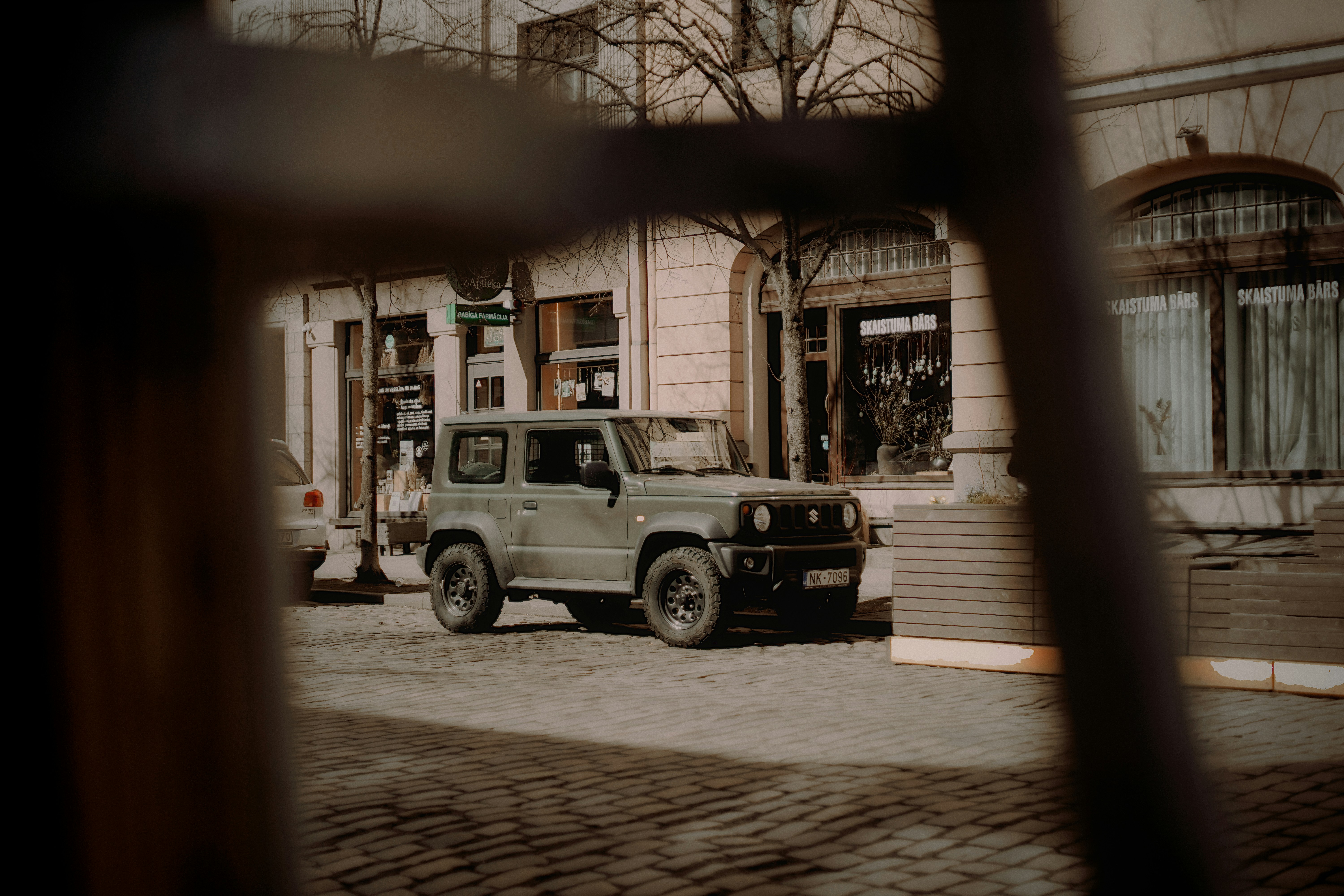 Un SUV verde parcheggiato su una strada di ciottoli.