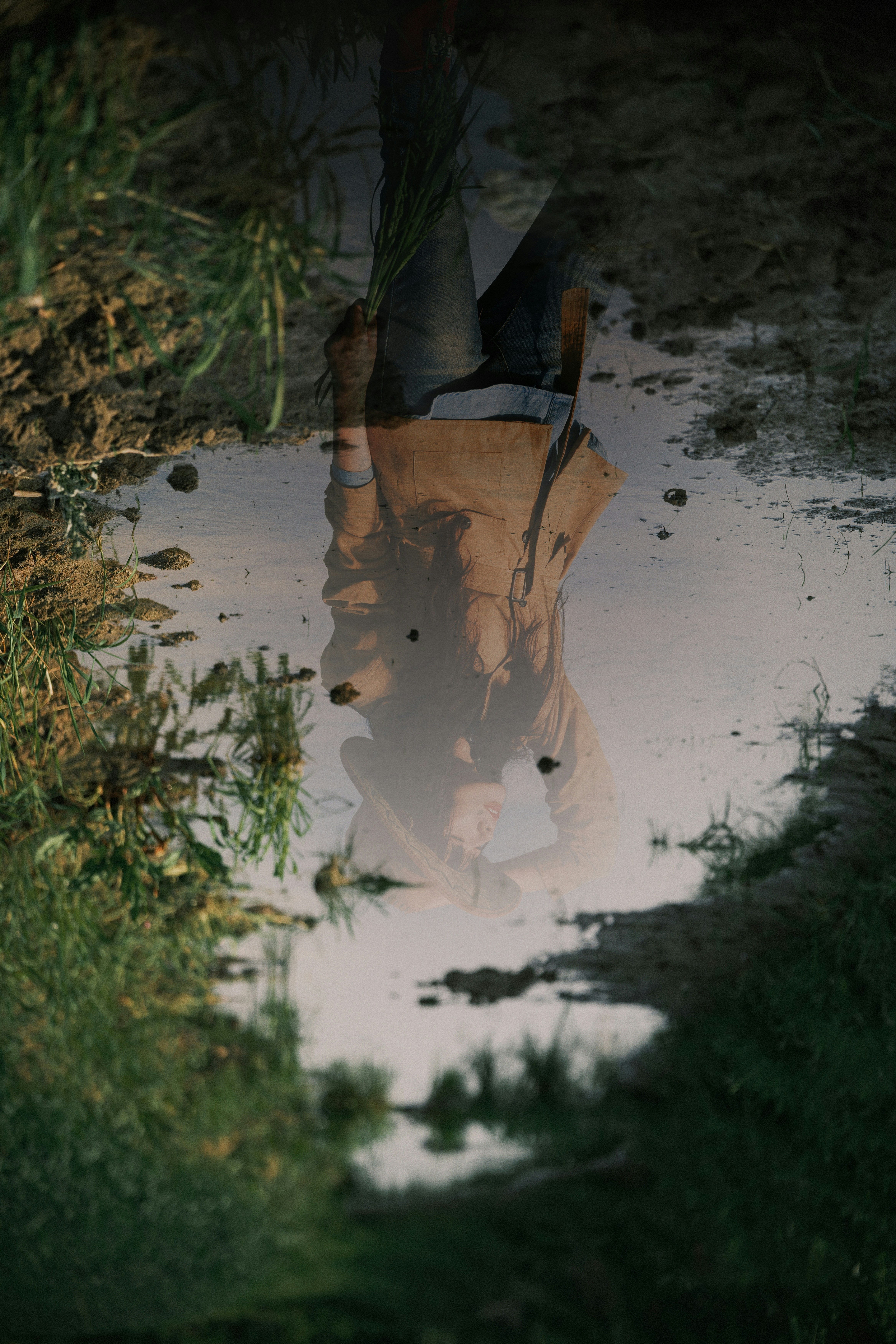 Reflection of a person in a muddy puddle