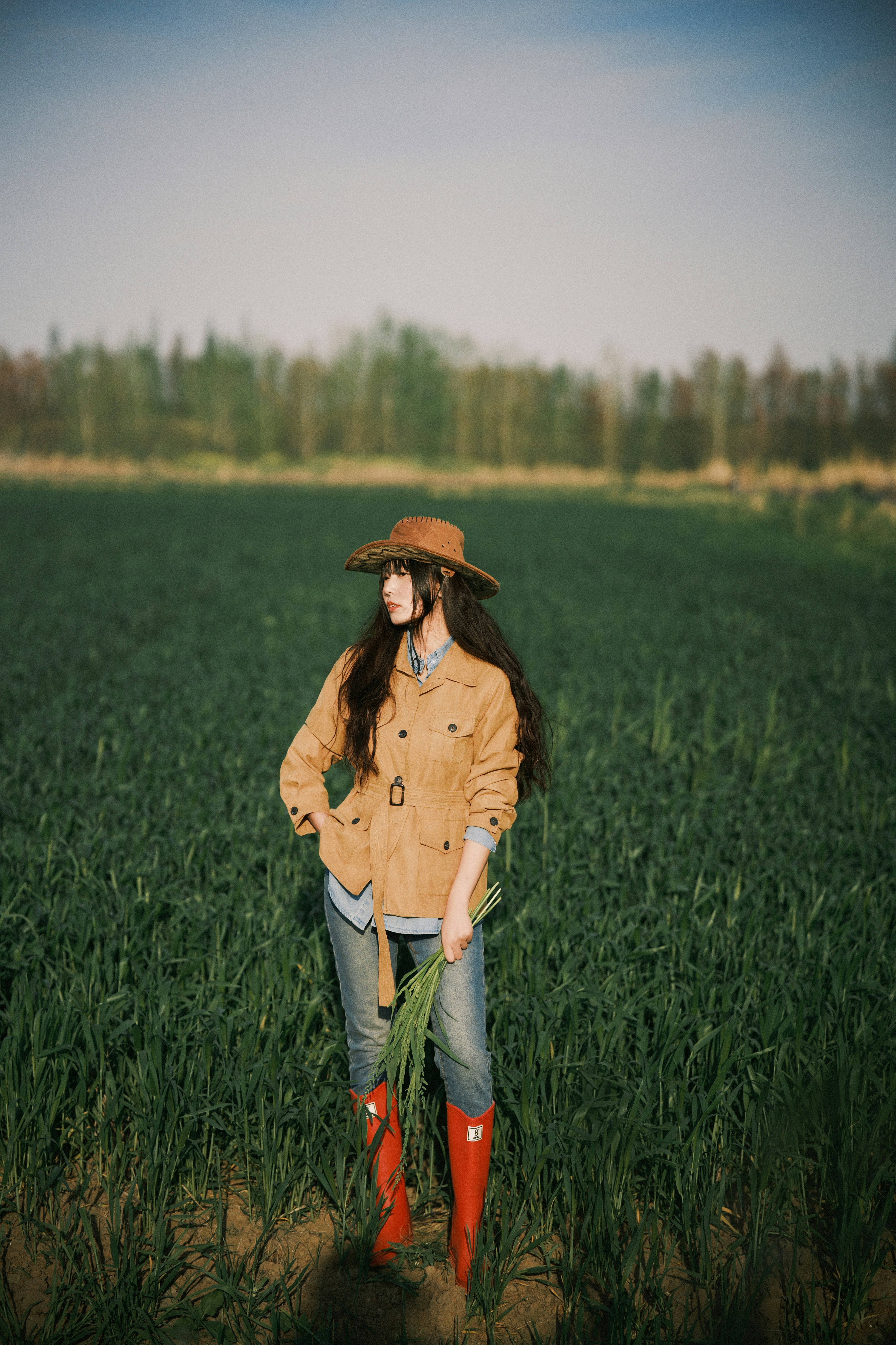 Woman in hat standing in a green field