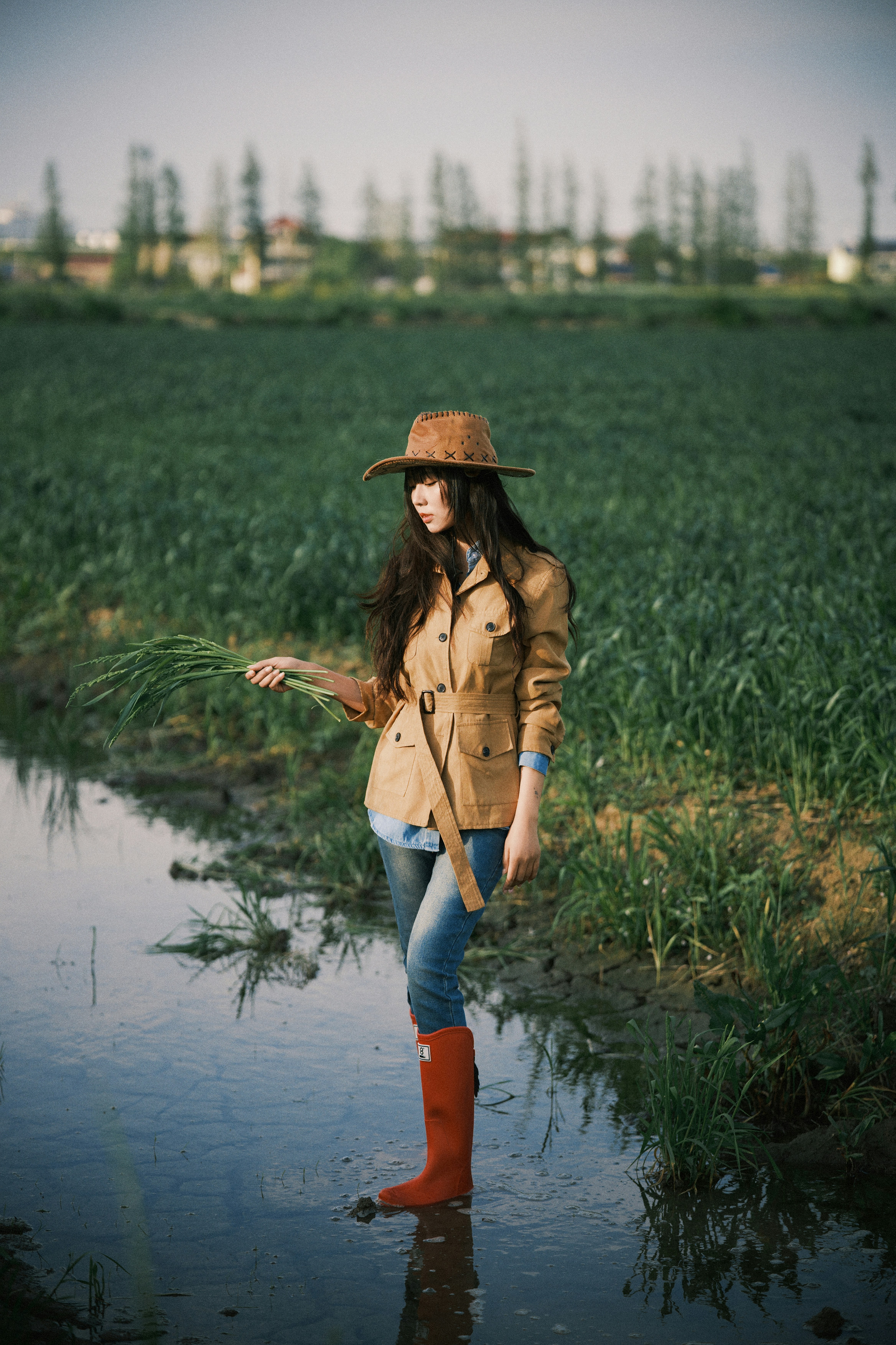 Woman in hat and boots standing in a muddy field. photo – Free ...