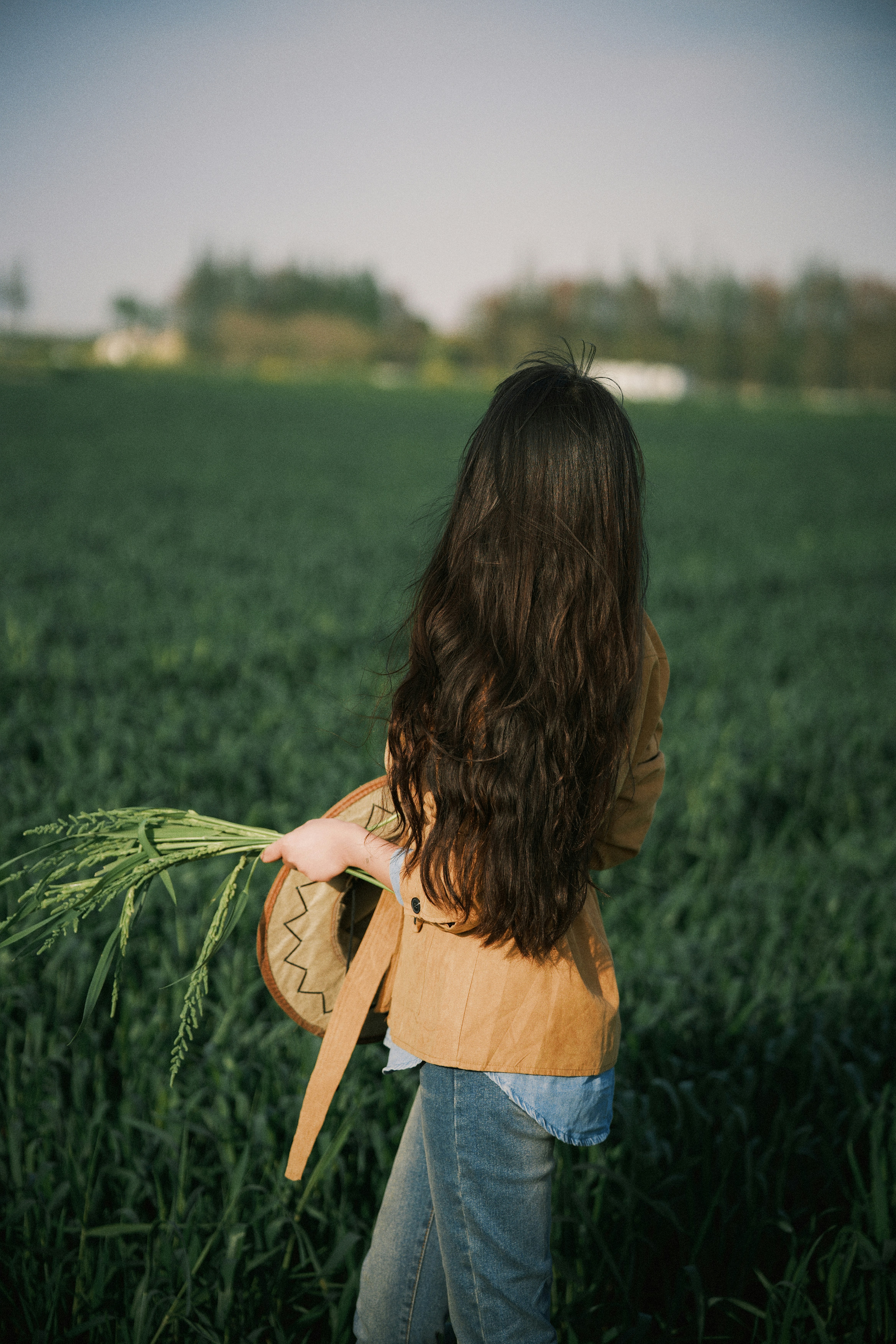 Woman with long dark hair in a green field