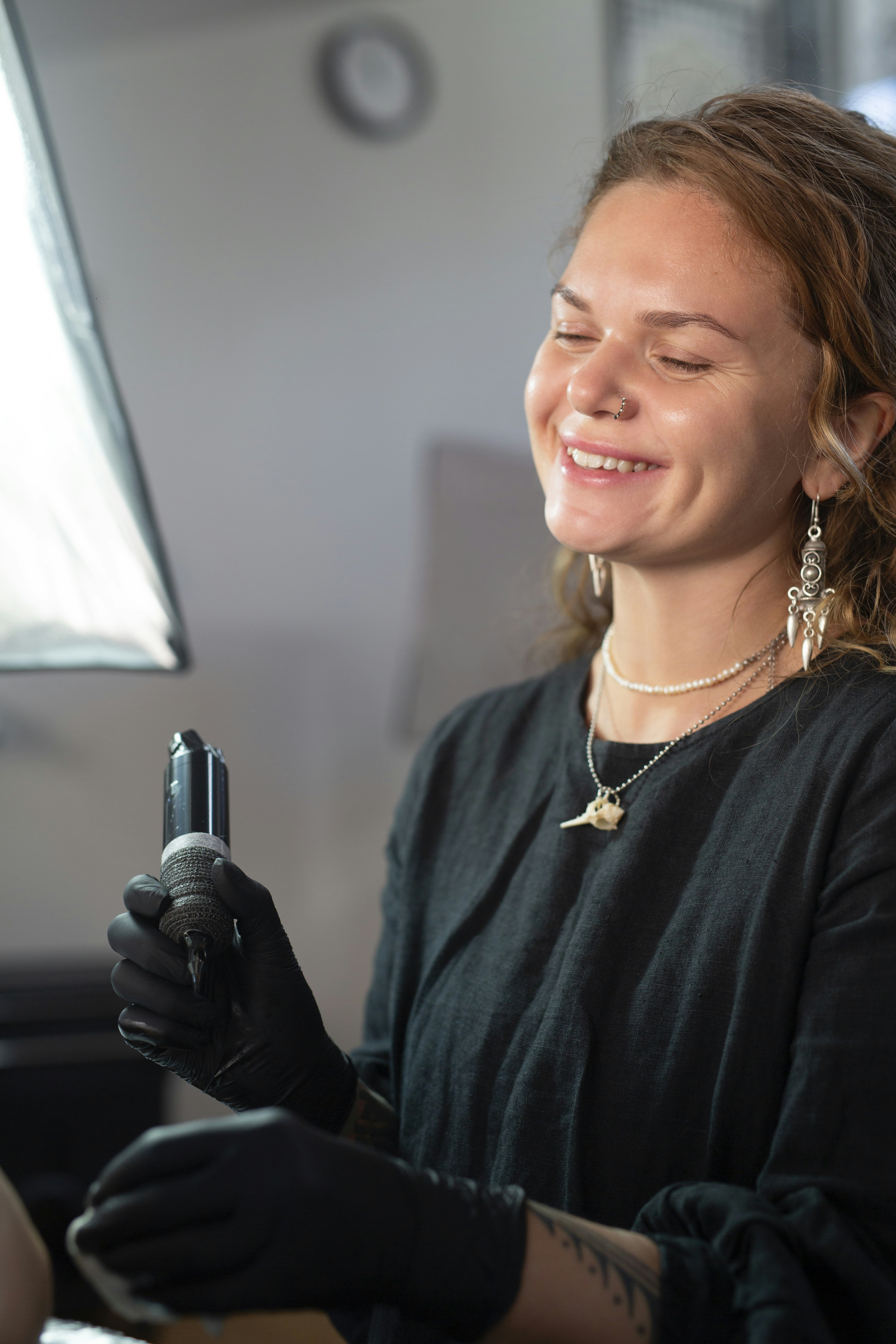 Tattoo artist smiling while holding tattoo machine